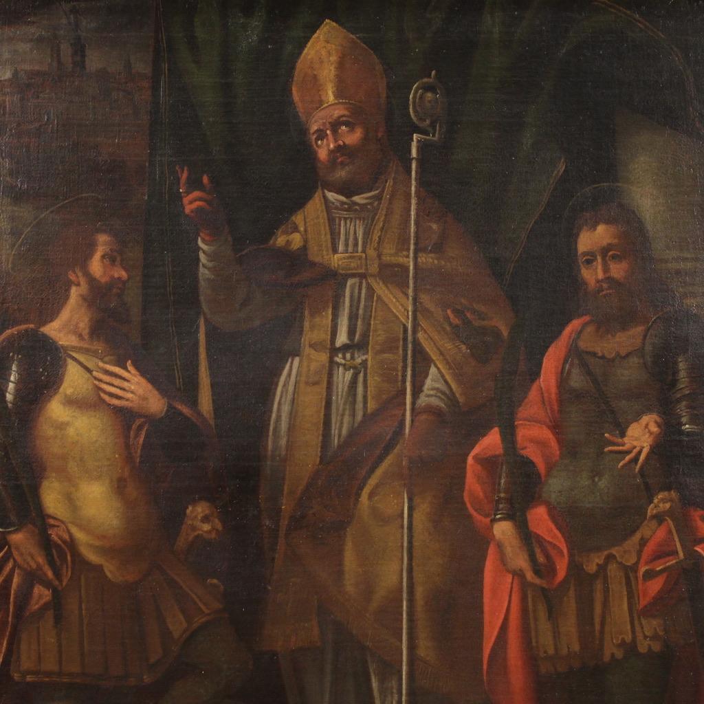 Antike religiöse Malerei aus dem 17. Jahrhundert. Kunstwerk in Öl auf Leinwand, das eine Dreifaltigkeit von Glaubenskriegern darstellt: Fermo, Proloco und Rustico, geliebte Heilige der lombardischen Tradition. In der Mitte segnet der Heilige Proloco