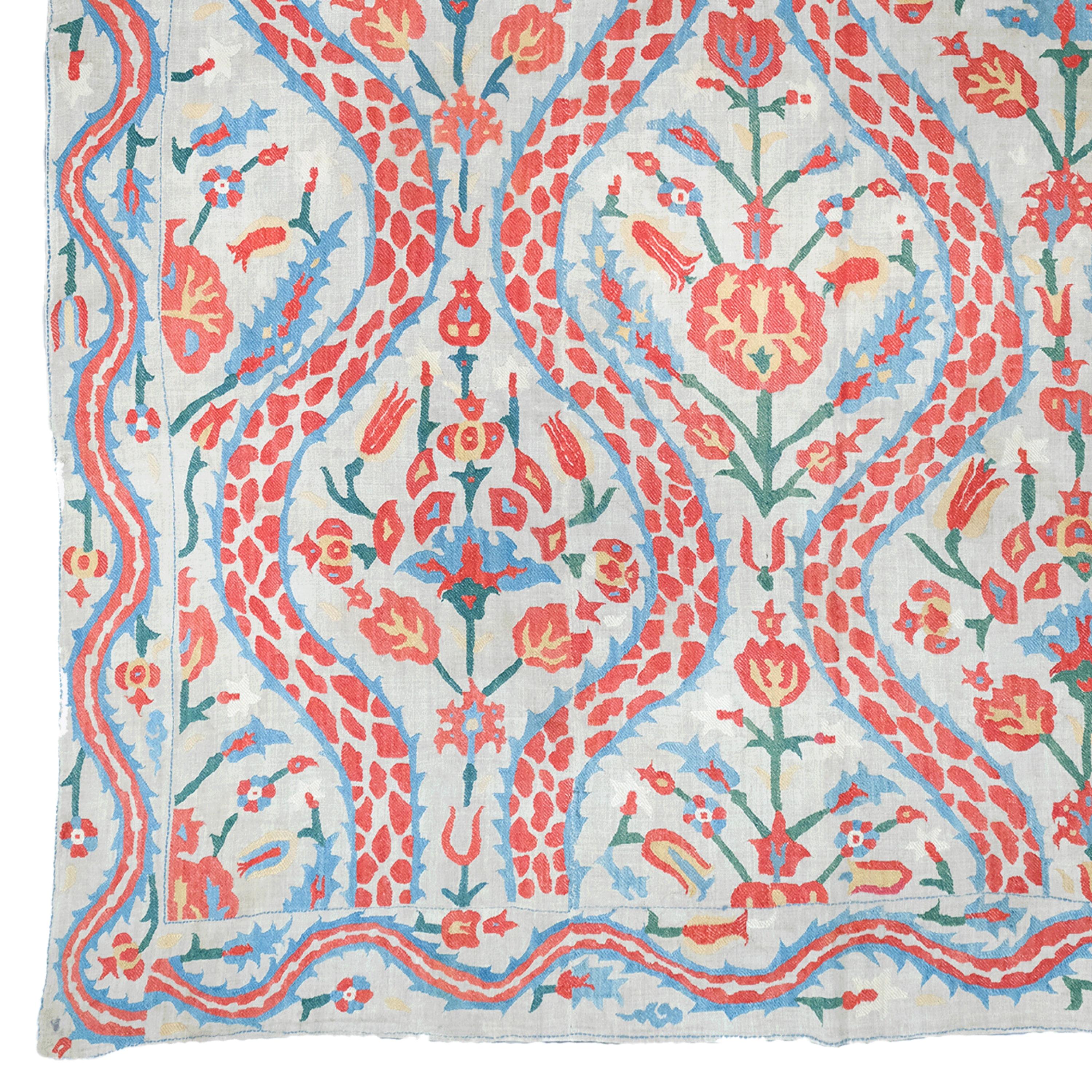 This special collector's item is a rare and valuable textile from the Ottoman period, dating from the 17th century. This work, expertly woven from cotton and silk, is adorned with symmetrical floral motifs and ornaments that reflect the rich