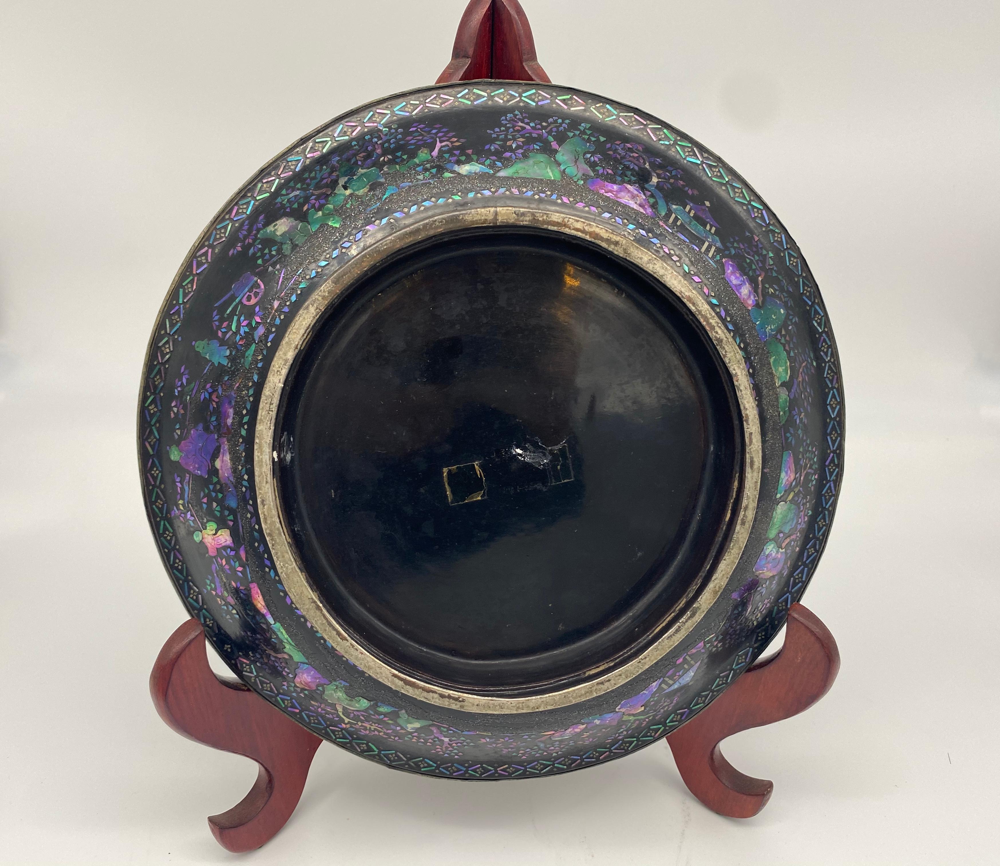 Pair of Chinese silver, lacquer, and mother of pearl plates from the 17th century. A matching pair of ornamental antique Chinese plates, the faces each of a thin sheet of distressed silver over a body of black lacquered wood with mother of pearl