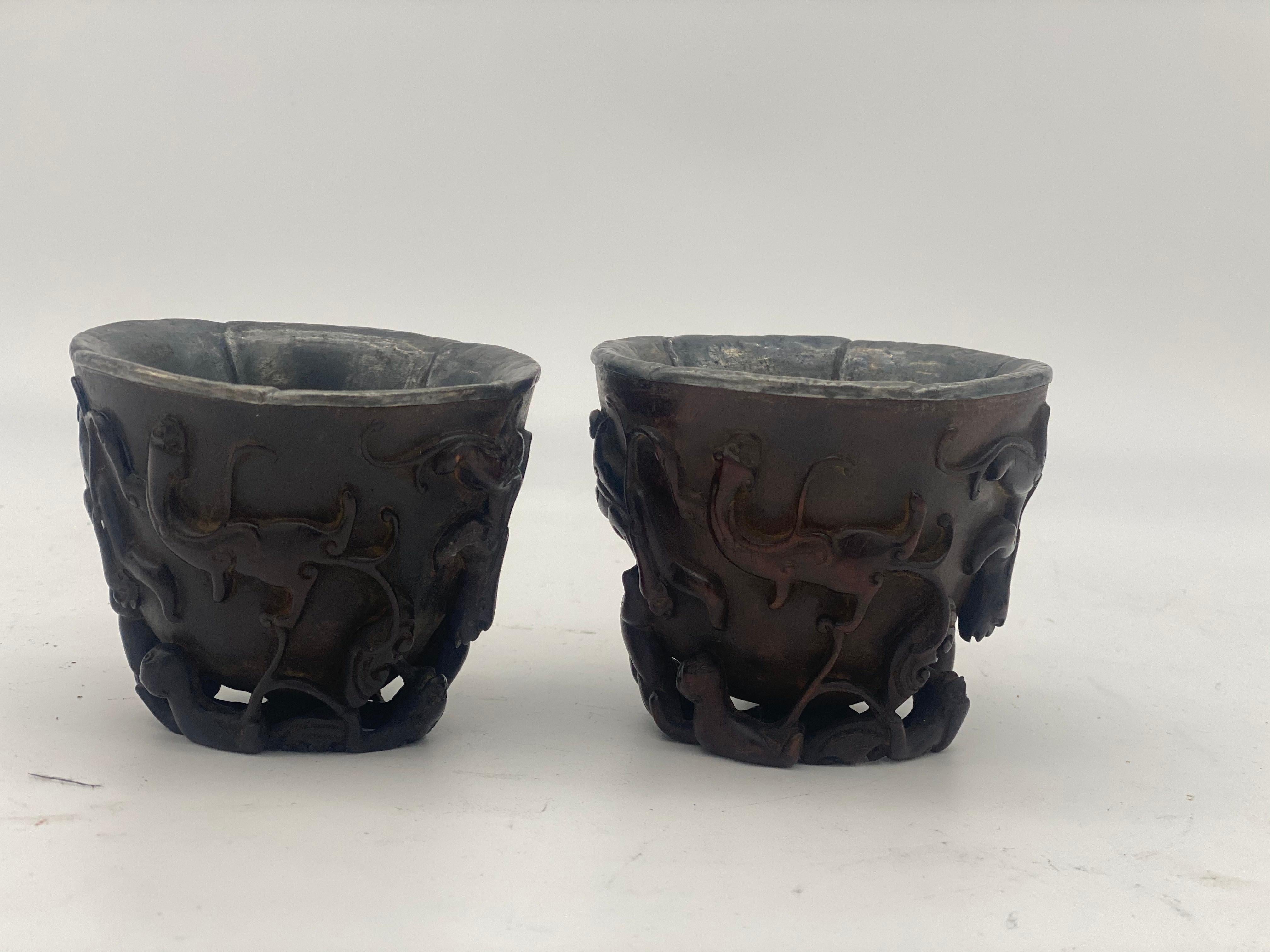 17th century a pair of Ming dynasty Chinese ZiTan inlaid silver cups, the exterior carved in high relief and undercut around the sides and base with Chi dragon, 5 edges with silver lining, dimensions: 8.5cm x 7.2cm high.
