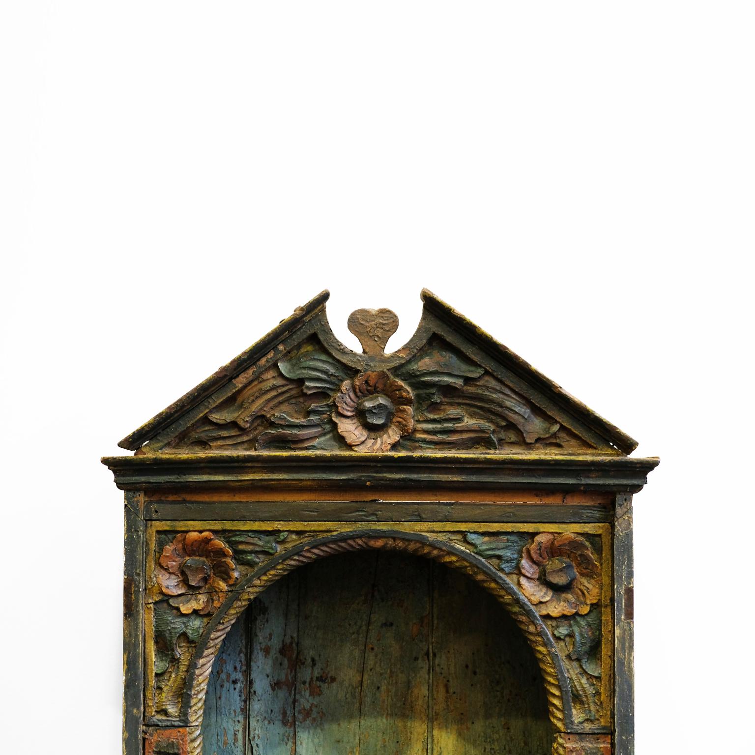 Portuguese Oratory of XVII century, in rustic wood carved manually in the form of gold wreaths and red roses. Probably of colonial origin, it resembles the Spanish Colonial style. The original background boards with aged blue paint. The iron nails