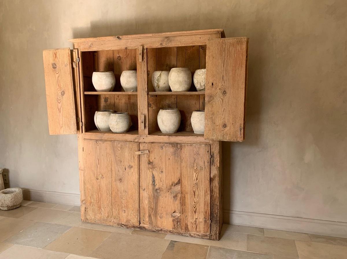 A 17th century Spanish mountain cupboard. Holding 4 doors with the upper doors doublehinged. The interior comprising 2 shelves. This cupboard is completely made from large planks of mountain pine. This type of construction originated from medieval