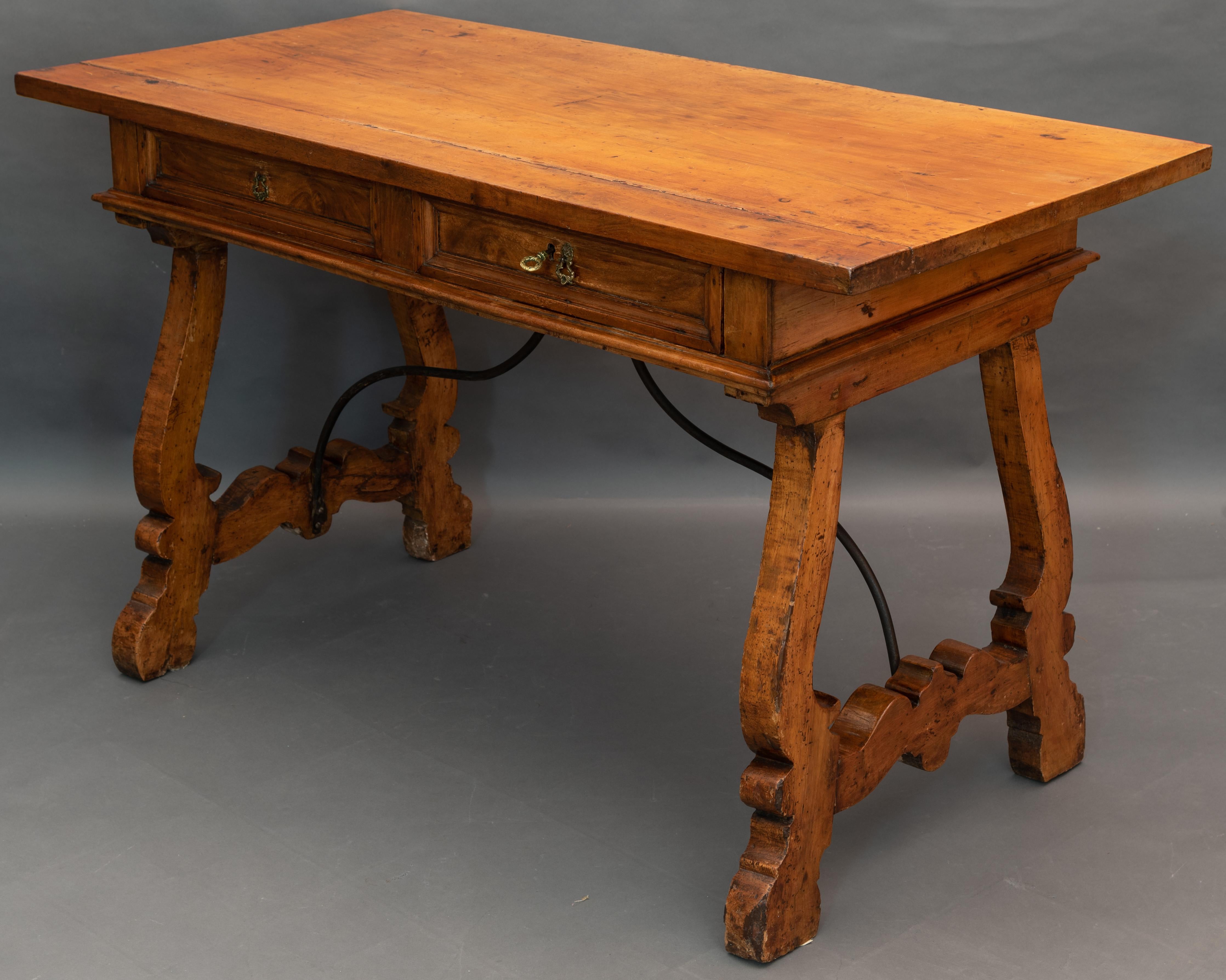 Refectory table in Tuscan walnut with rectangular top with two drawers in a row. 
The table is on lovely lyre legs united by a curved wrought iron fitting. 
There is a key and each drawer has a different style lock. 

All made from solid