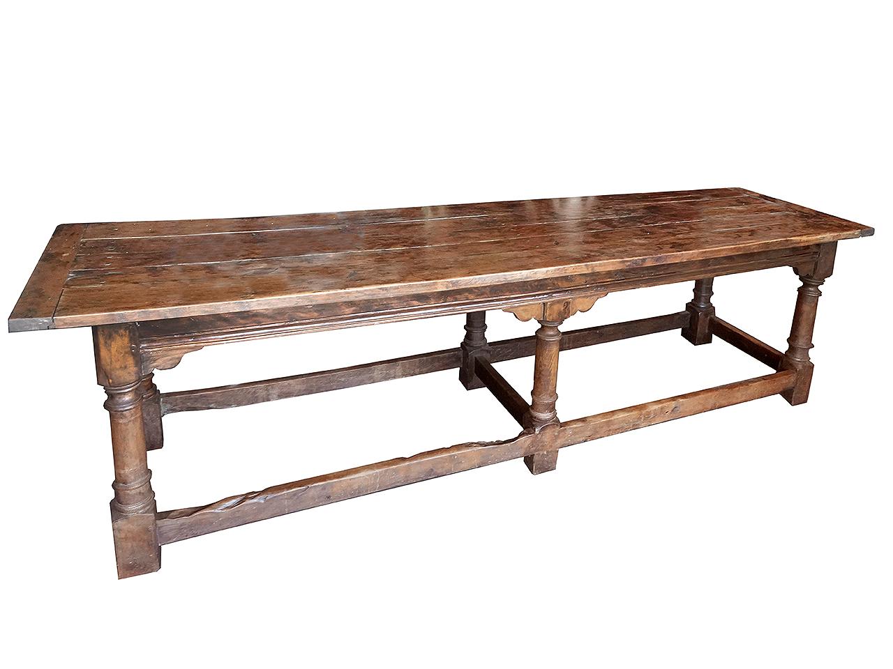 The table is three-plank and raised on six baluster supports united by stretchers. The rails on all four sides are simple in design and works equally in a traditional or modern setting. It is well over 9 foot long and very impressive. I am not sure