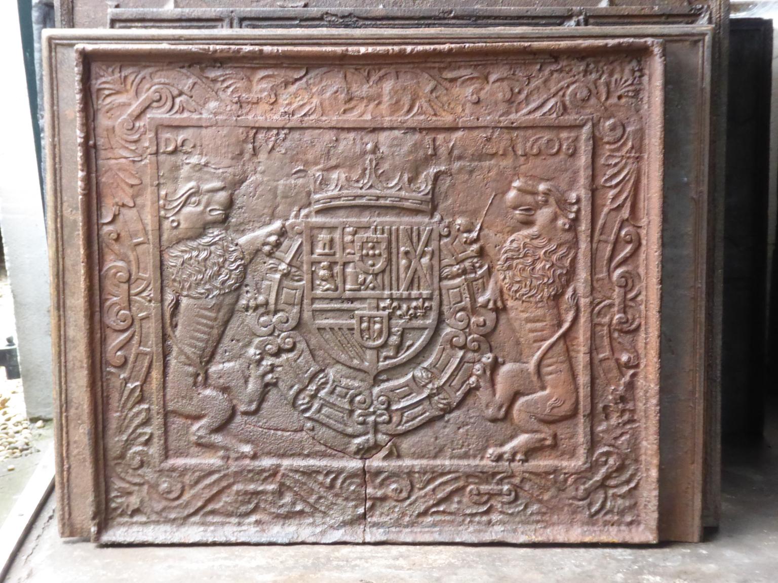 Plaque de cheminée Renaissance avec les armoiries de Philips III d'Espagne. La plaque de cheminée est en fonte et a une patine brune. La plaque de cheminée présente de graves fissures et ne peut être utilisée qu'à des fins décoratives ou comme