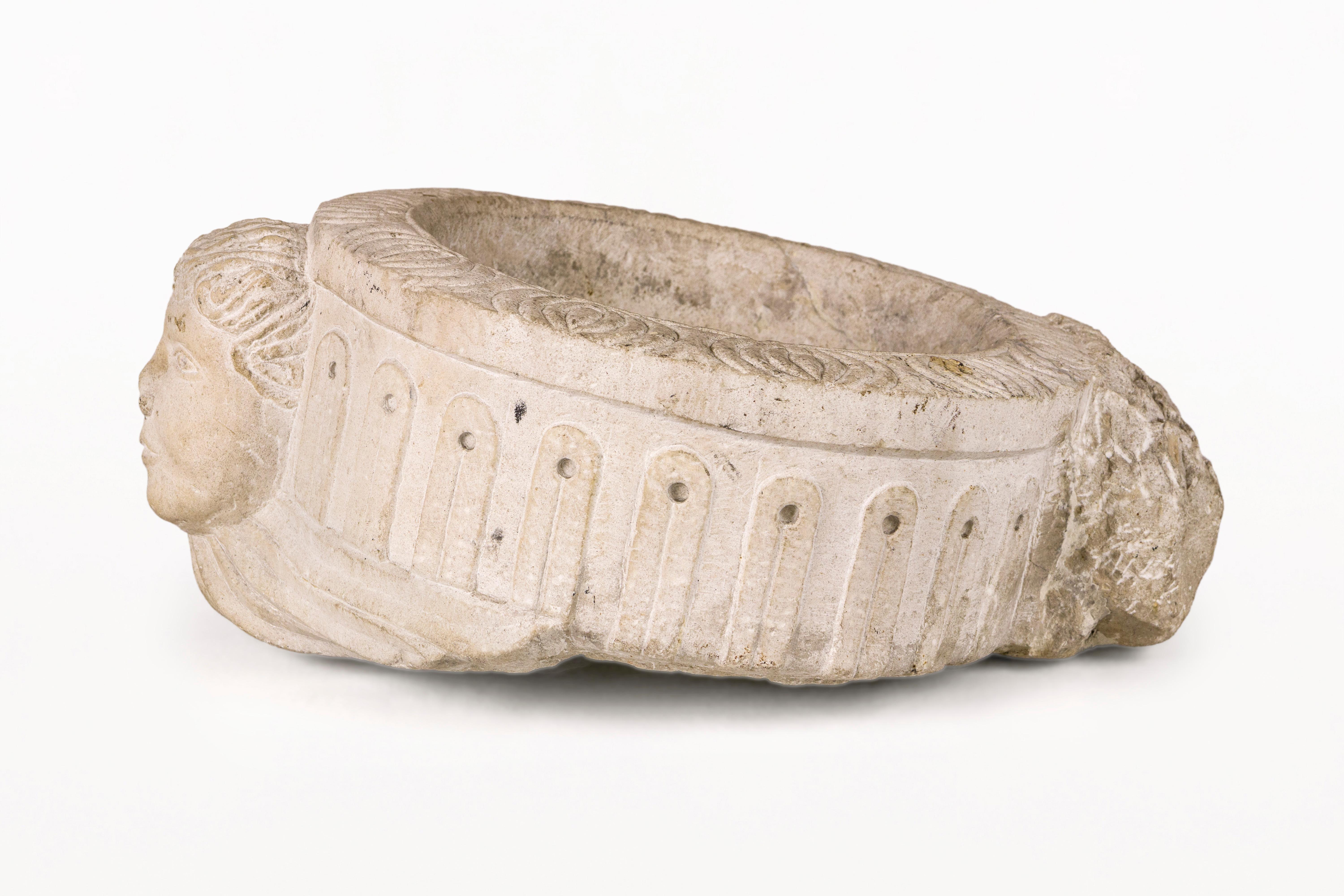 DESCRIPTION: 17th Century Sculpted Stone Benitier, Circa 1600’s, Spain
Late Renaissance round limestone benitier, depicting the face of a cherub with an architectural  frieze boarder.

CONDITION: Good condition. Wear consistent with age and