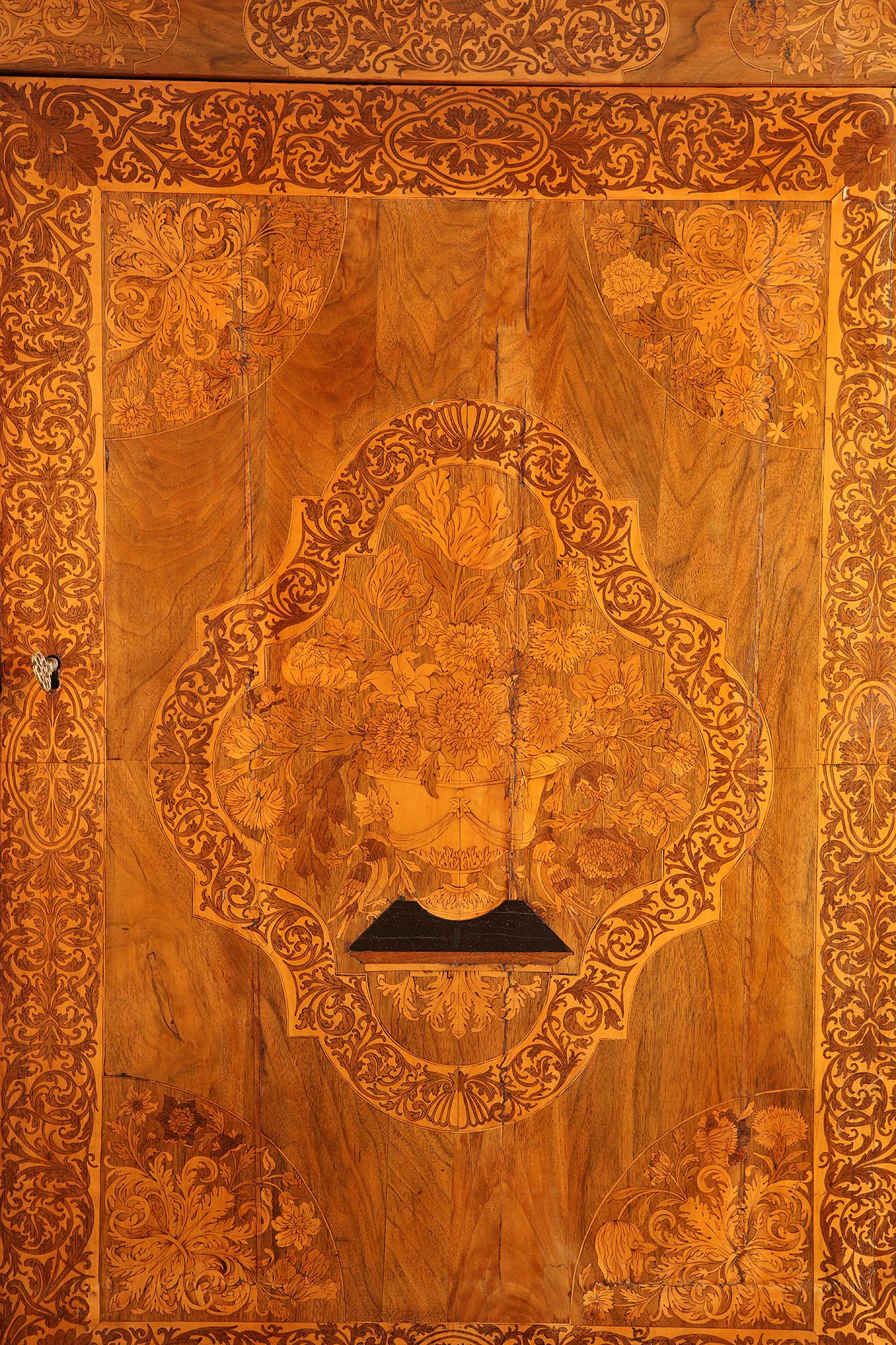 Magnificent cabinet on stand attributed to Gerrit Jensen (active 1680-d.1715). The cabinet with doors and sides veneered in seaweed marquetry and arabesques around central floral marquetry panels. The whole raised on square tapering legs with curved