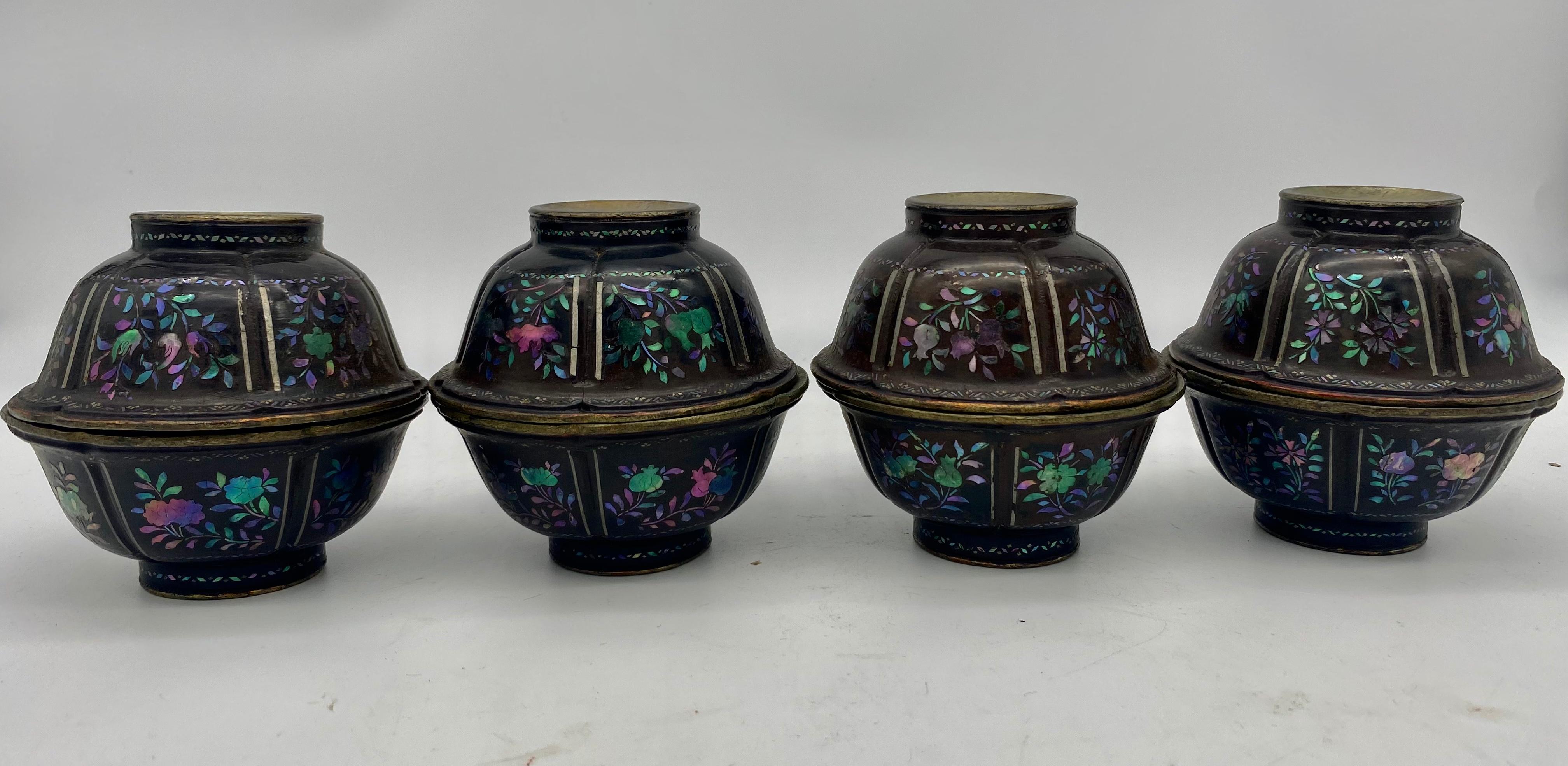 A fine set of 8 pieces Chinese lacquered and mother of pearl inlaid bowls with silvered interiors from the 18th century Qing Dynasty, The faces each of a thin sheet of distressed silver over a body of black lacquered wood with mother of pearl