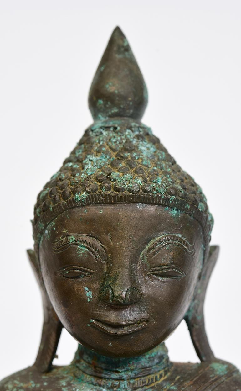 Burmese bronze Buddha sitting in Mara Vijaya (calling the earth to witness) posture on a base.

Age: Burma, Shan Period, 17th century
Size: Height 19.2 C.M. / Width 10.5 C.M. / Thickness 6.7 C.M.
Condition: Nice condition overall (some expected