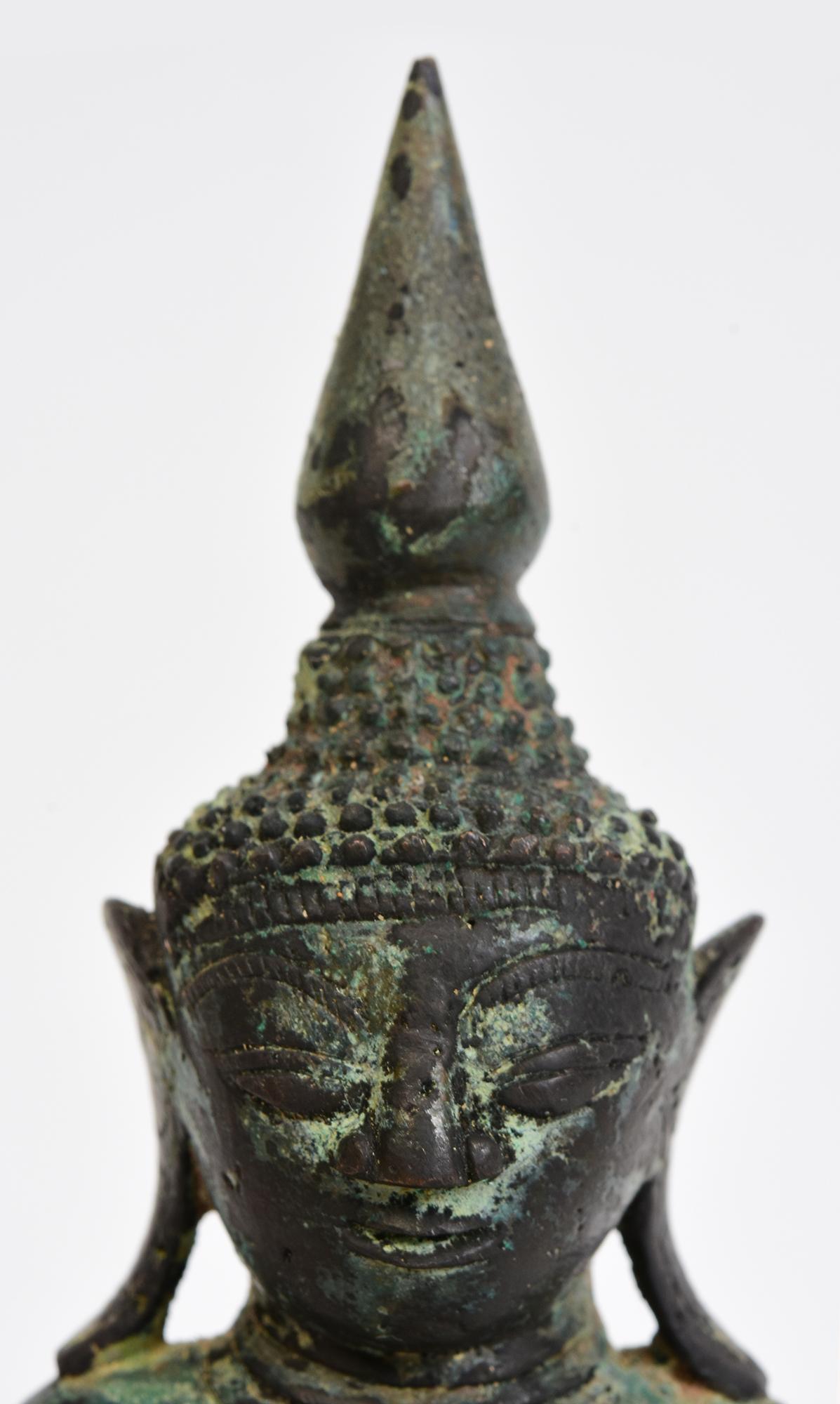 Antique Burmese bronze Buddha sitting in Mara Vijaya (calling the earth to witness) posture on a base.

Age: Burma, Shan Period, 17th Century
Size: Height 20.3 C.M. / Width 9.2 C.M. / Depth 5.5 C.M.
Condition: Nice condition overall (some expected