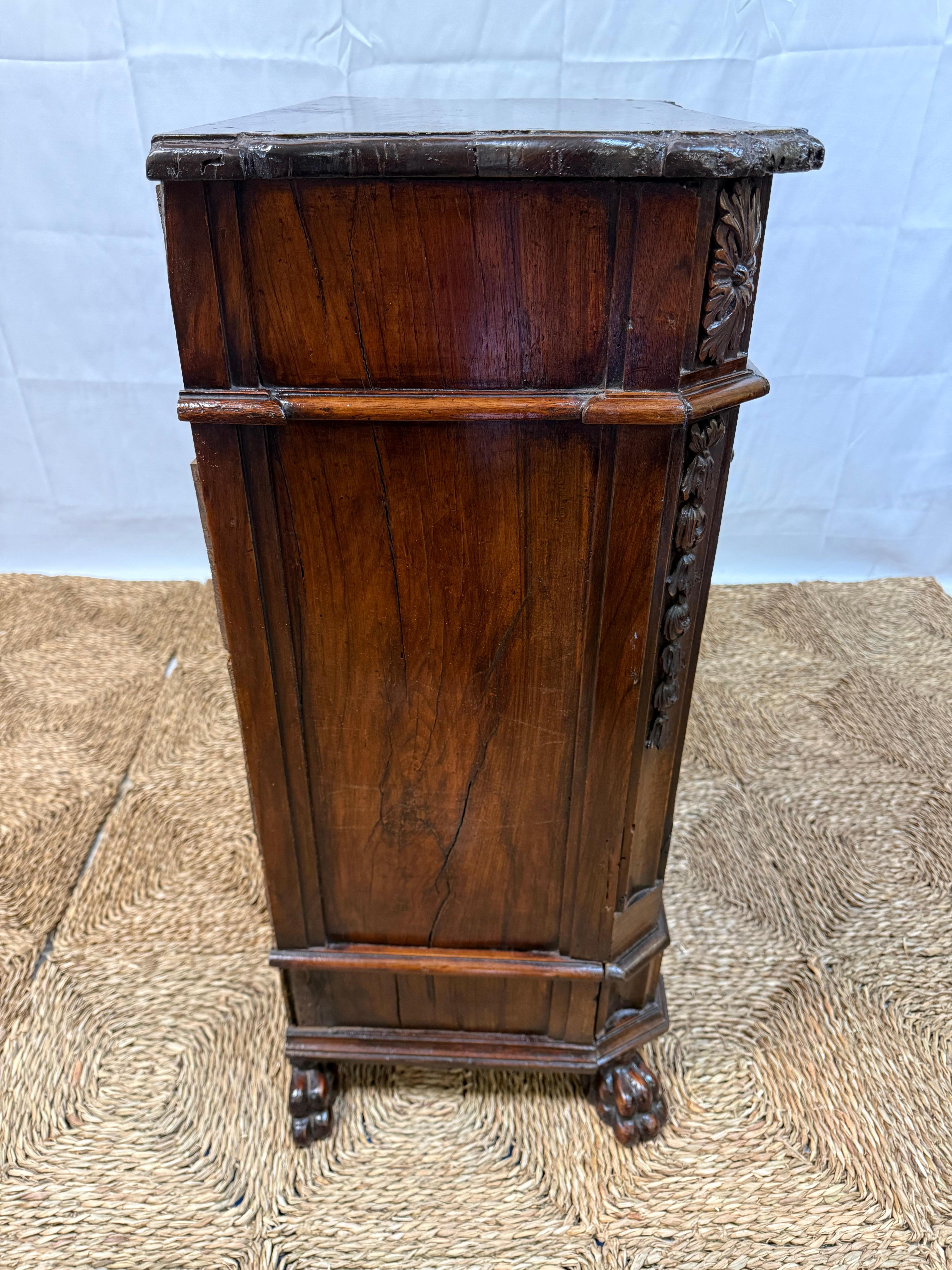 Exceptional 17th Century Italian Walnut Commodino. Crafted with remarkable attention to detail, this rare antique features five generously sized drawers, all adorned with original period hardware that speaks to its rich history. The warm, lustrous