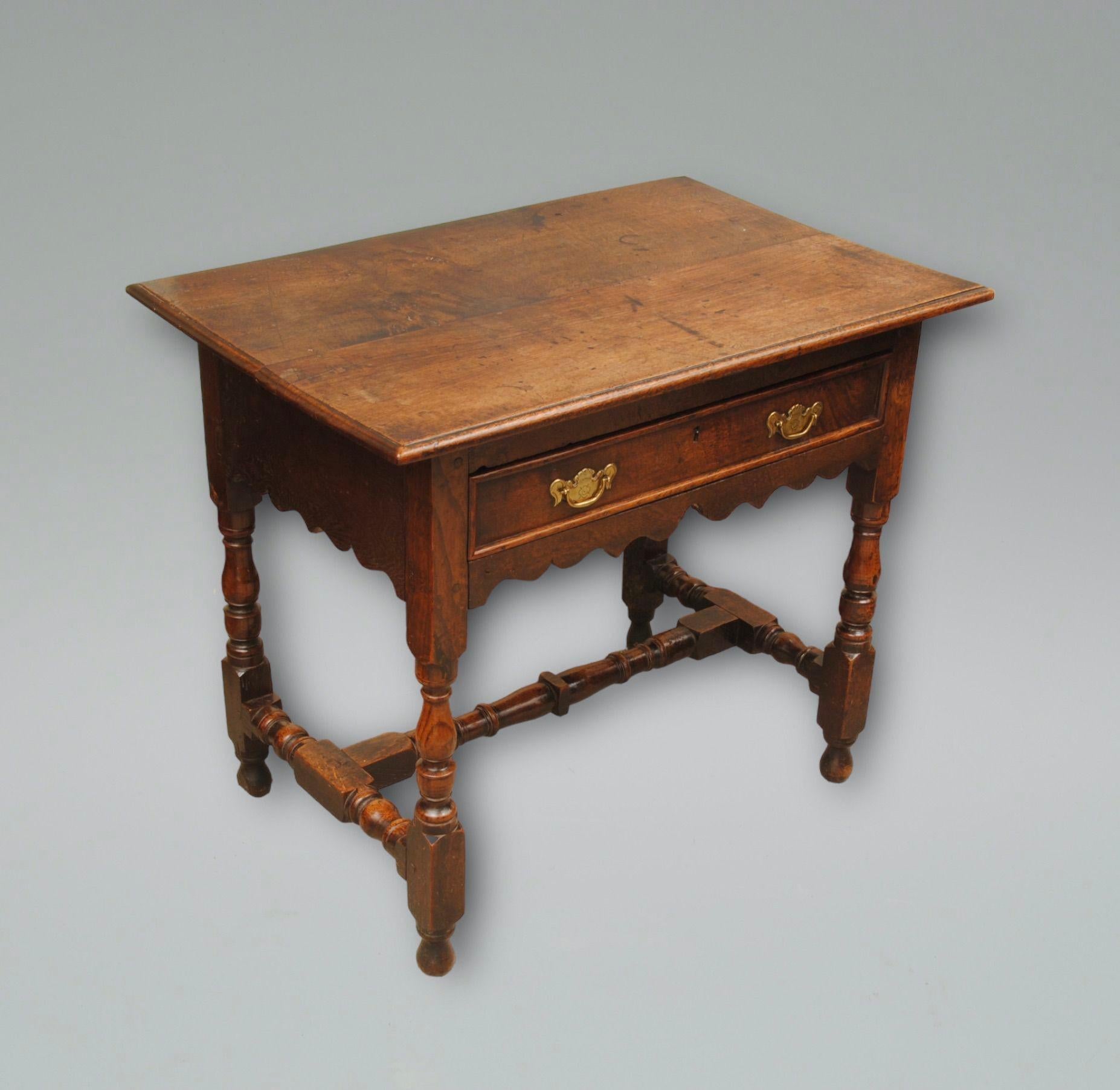 A late 17th century oak side table with turned legs and stretchers, original handles to the single drawer above a wavey frieze. good mellow colour and deep patination