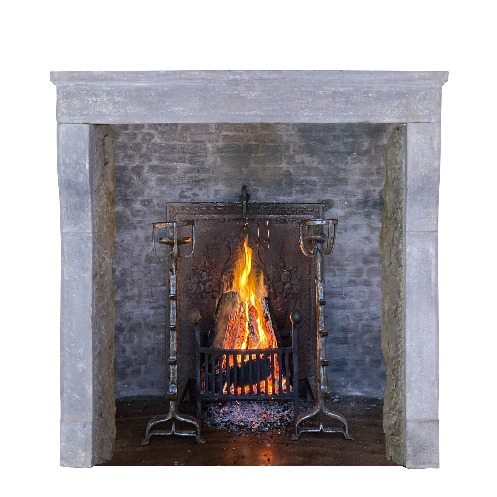 This is a very unusual fireplace surround in French hard limestone. This mantle boasts very fine detail and its original patina. It is composed of three solid blocks and is ready for installation. Its simple country, yet elegant style will make a