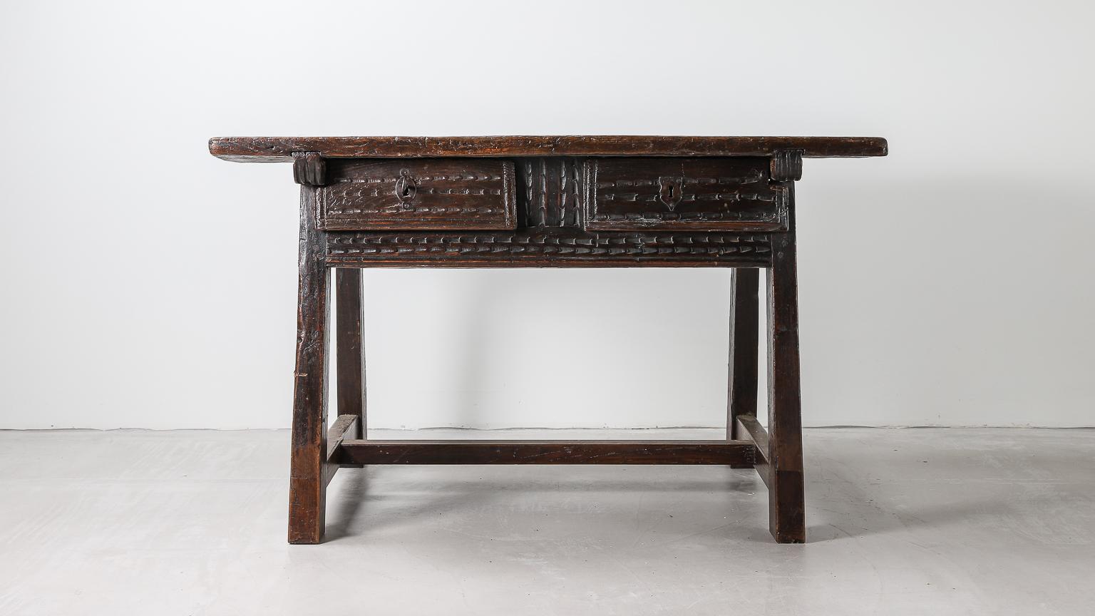 Original 17th century Spanish Baroque inlaid walnut desk or centre table, with a rectangular single plank top above a frieze fitted with two chip carved drawers, with similarly carved panels below and to the rear, standing on angles legs with a