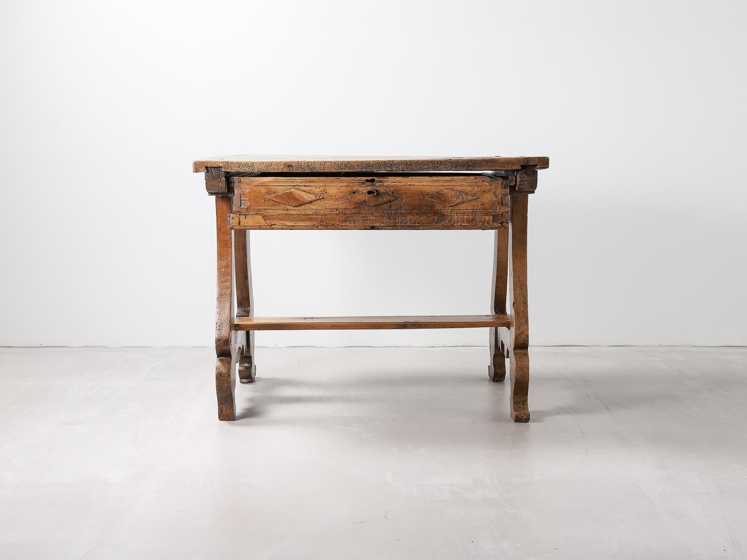 17th century Spanish Baroque walnut writing desk with iron details. 

The tabletop is two walnut boards with iron work detailing. The rest of the body consists of lyre shaped legs and a central support across the legs which will most likely have