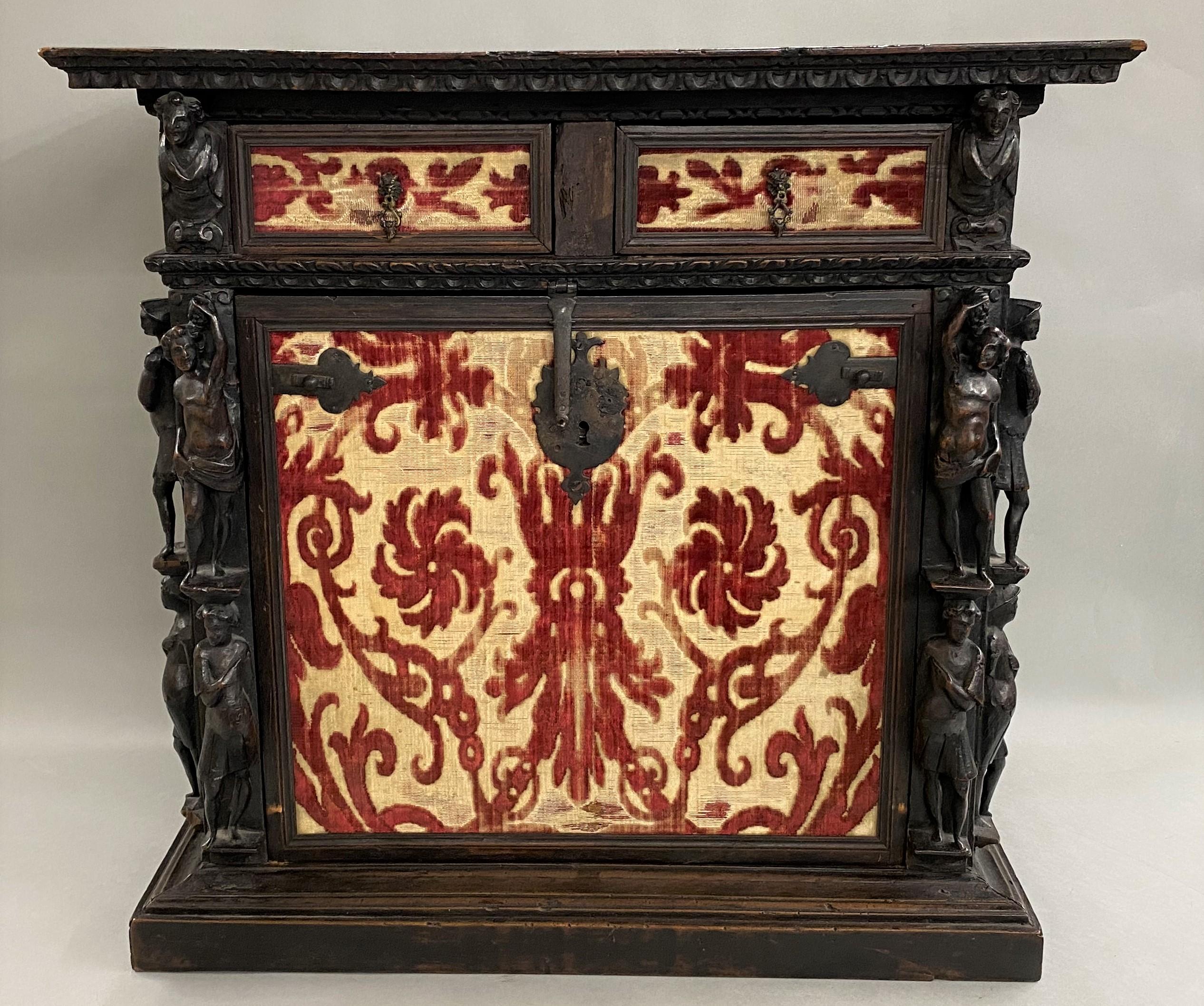 A fine example of a diminutive burled walnut vargueno, collector or valuables cabinet, with molded cornice and drop front, opening to a multi-drawer interior with two fitted upper drawers with fabric fronts surmounting a center block of drawers,