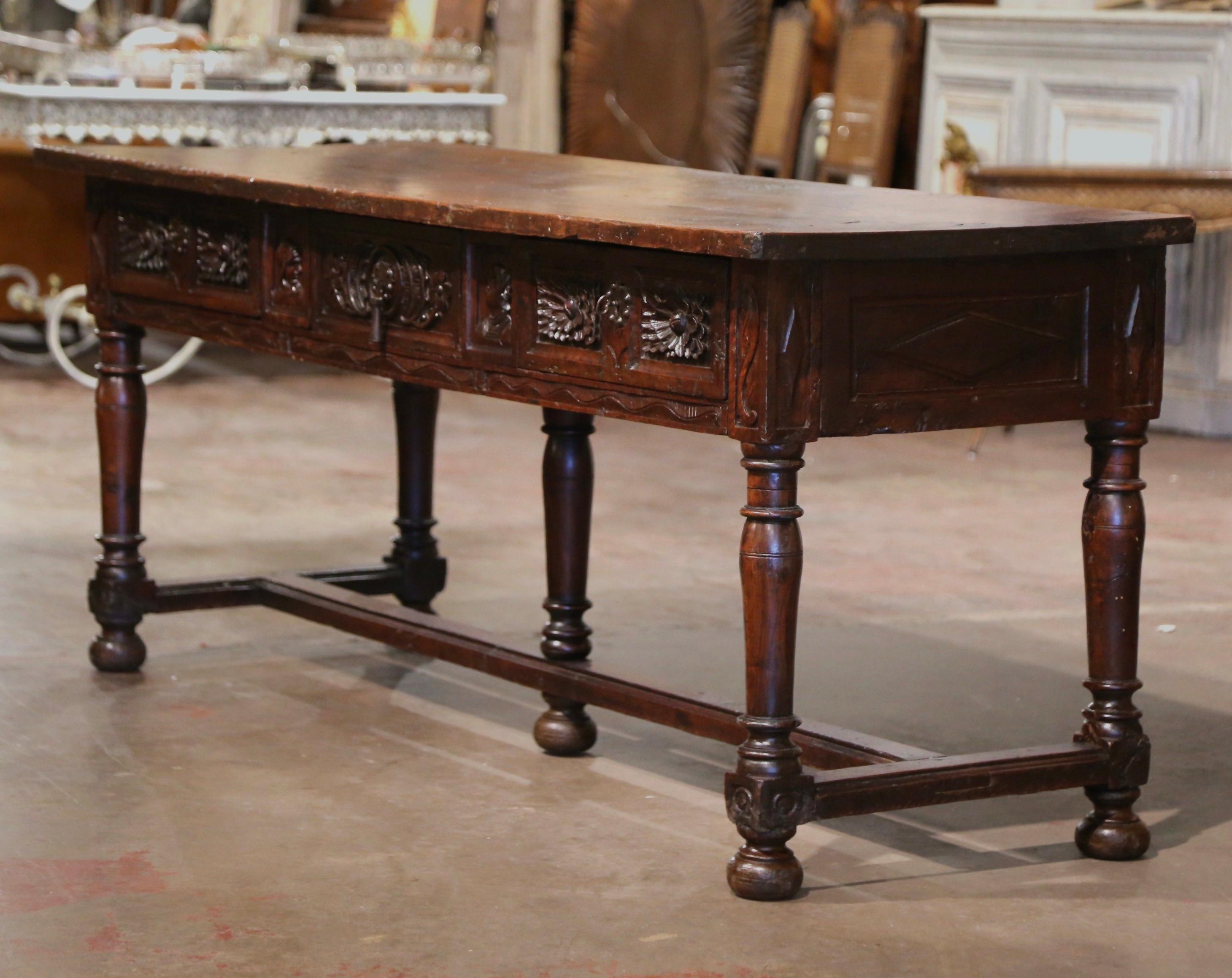 This elegant antique fruitwood console was crafted in Spain, circa 1680. Hand carved on all four sides, the long sofa table stands on five thick turned legs ending with bun feet over a bottom stretcher at the base. The console features a single