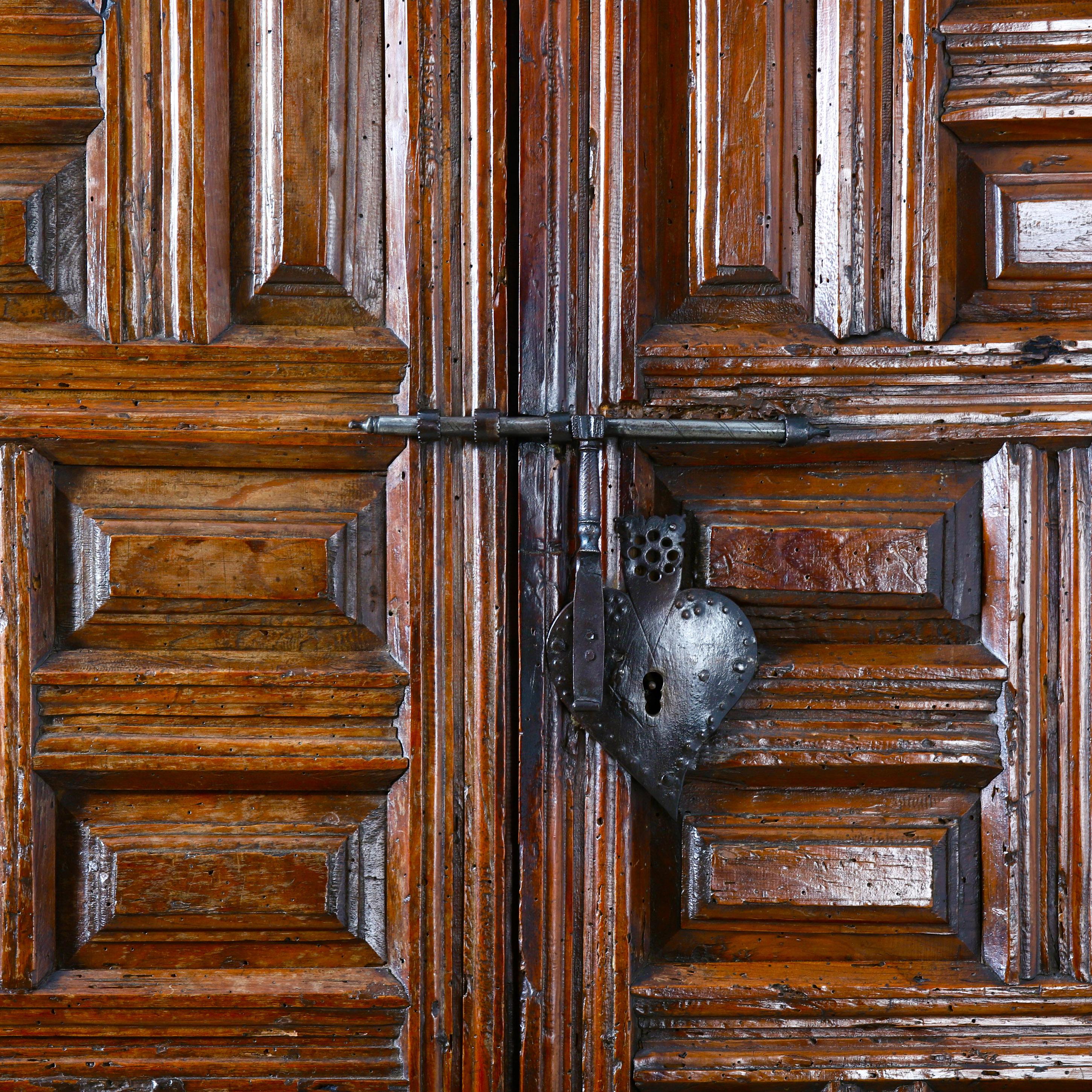 A charming provincial 17th century Spanish cupboard all carved from solid walnut, with geometric panels, and wonderful original ironwork in the shape of a love heart more than likely indicating this would've been a wedding gift or marriage