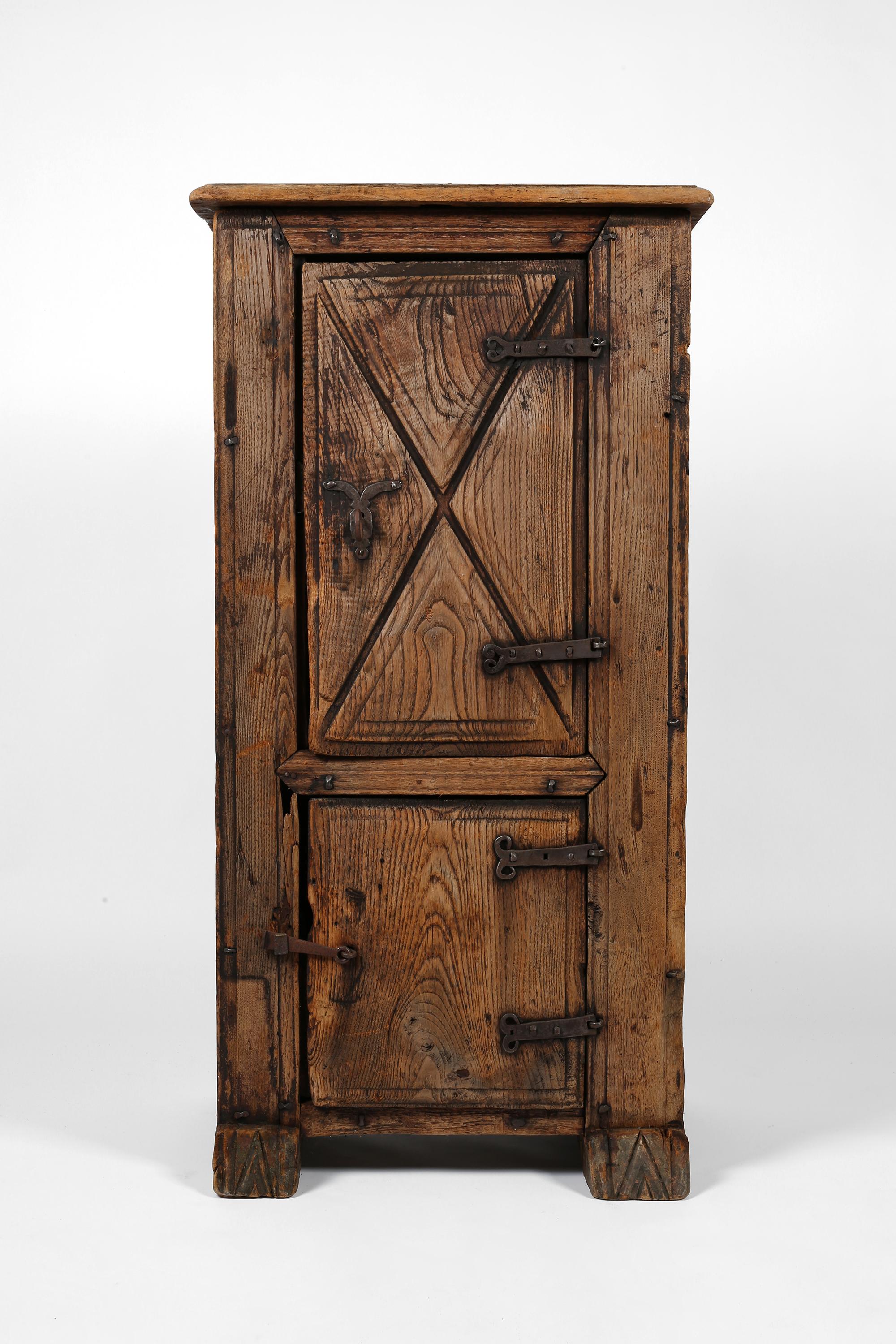 Encantador armario de dos puertas del siglo XVII, de madera de castaño tallada y ahora muy patinada, con herrajes originales de hierro forjado. 

Esta pieza, a menudo denominada 