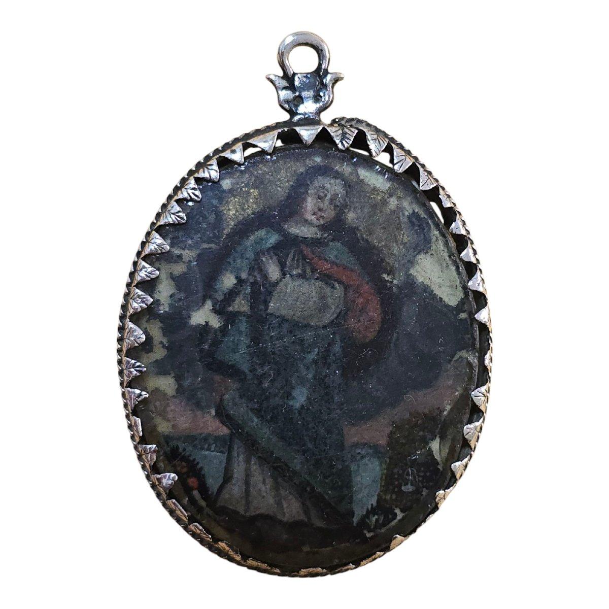 Un reliquaire raffiné et dévotionnel en argent sterling du XVIIe siècle, orné d'une délicate peinture en verre inversé de la Vierge Marie. Cette pièce exquise illustre l'habileté et la sensibilité spirituelle de l'art ecclésiastique baroque. L'image