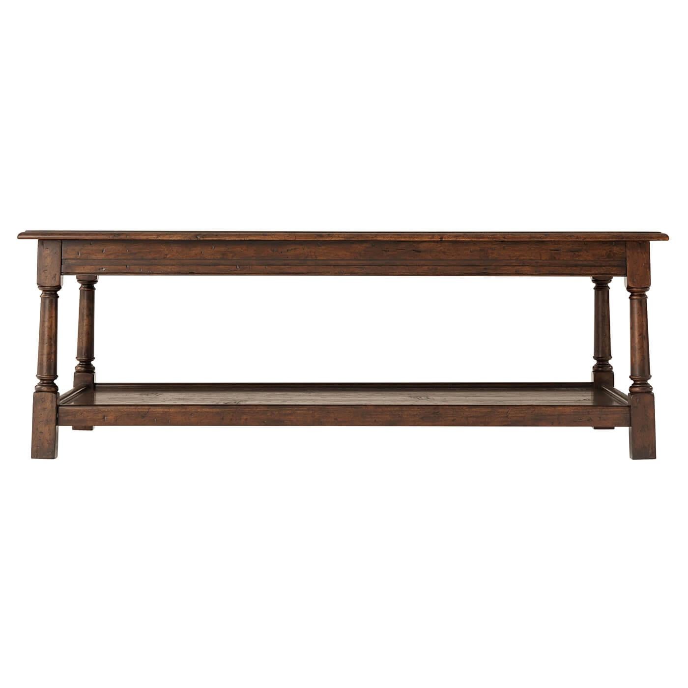 A 17th-century style mahogany and reclaimed oak occasional 'Joynt' cocktail table, the planked rectangular top with a molded edge, above a paneled frieze with gently splayed turned legs terminating in block feet joined by a planked tray under tier.