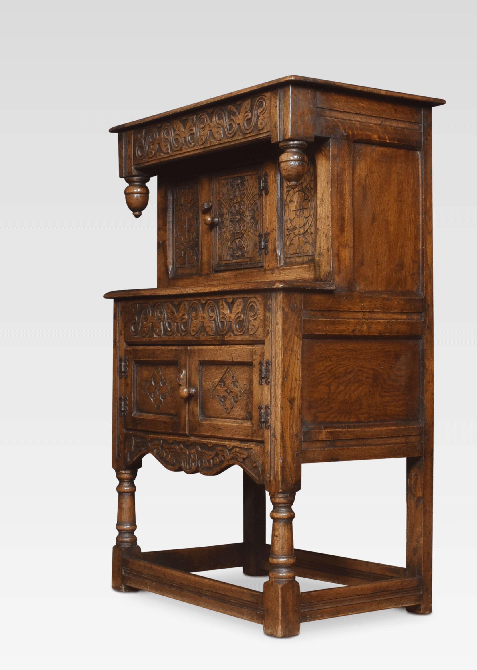17th century style dwarf oak court cupboard, the frieze flanked by pendant finials, above single cupboard door and two cupboard doors below. Raised on turned and tapering legs united by stretcher.
Dimensions:
Height 45 inches
Width 29