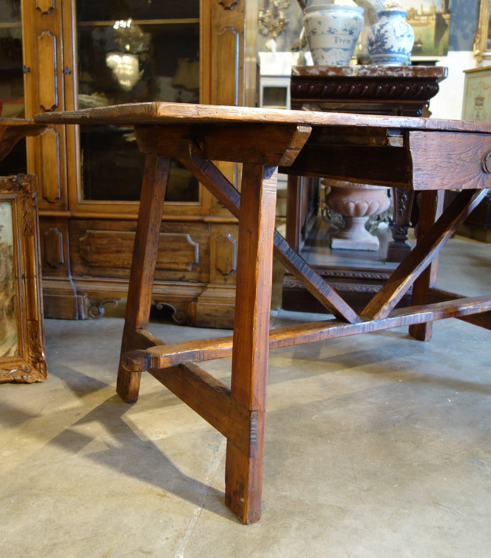 Primitivo rustic refectory style desk table:

Our “Primitivo” desk and table line; rustic, primitive plank top Tuscan farmhouse table with drawer and cross-stretchers, handcrafted in old fir solids, enhanced heavy grain texture, expertly finished in