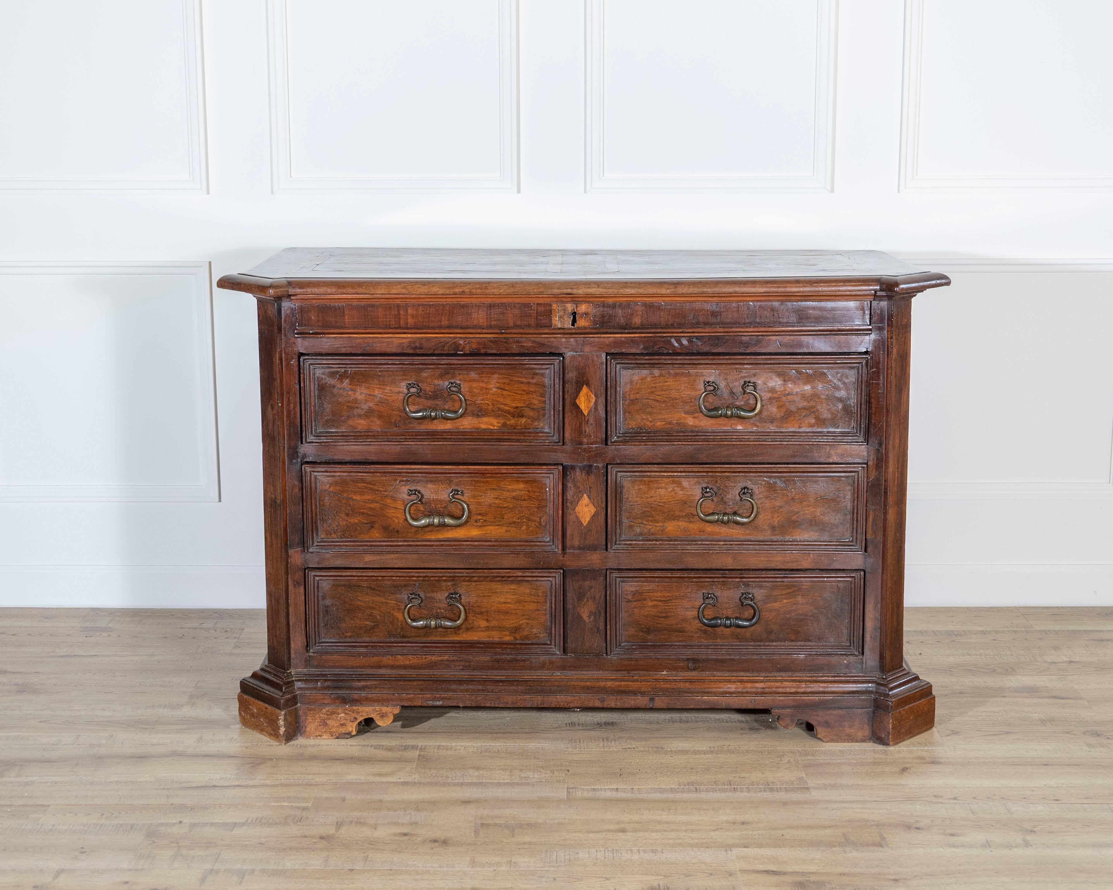A distinguished 17th-century Tuscan chest of drawers, crafted in solid and veneered walnut with elegant maple thread inlay. This superb piece exemplifies the refined woodworking traditions of early Baroque Tuscany, where proportion, craftsmanship,