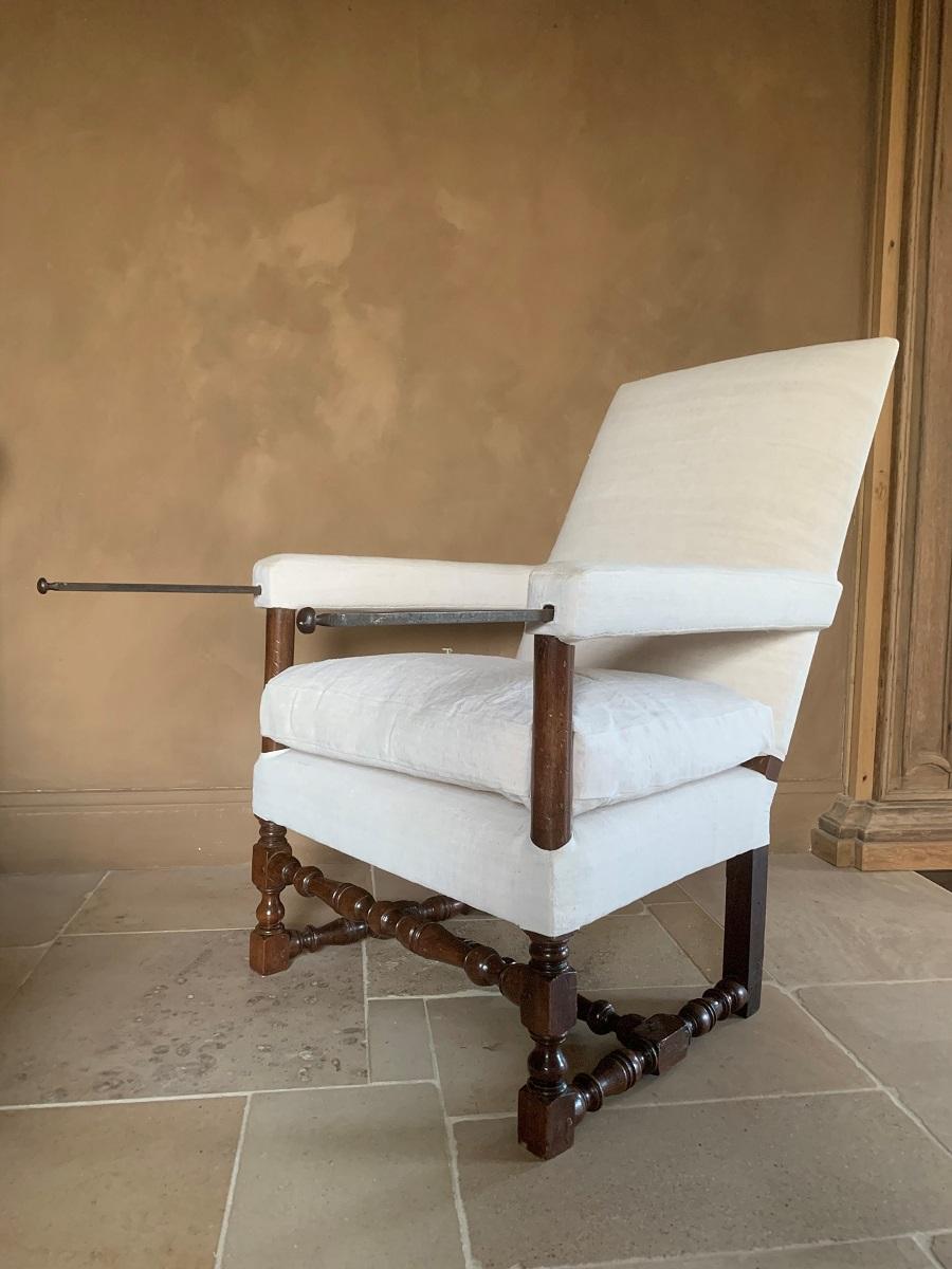 A 17th century French walnut armchair from the Dordogne region. The typical baluster shaped legs under a high back with upholstered armrest concealing tray supports. Armchairs as these were reserved for the upper classes. The larger part of people