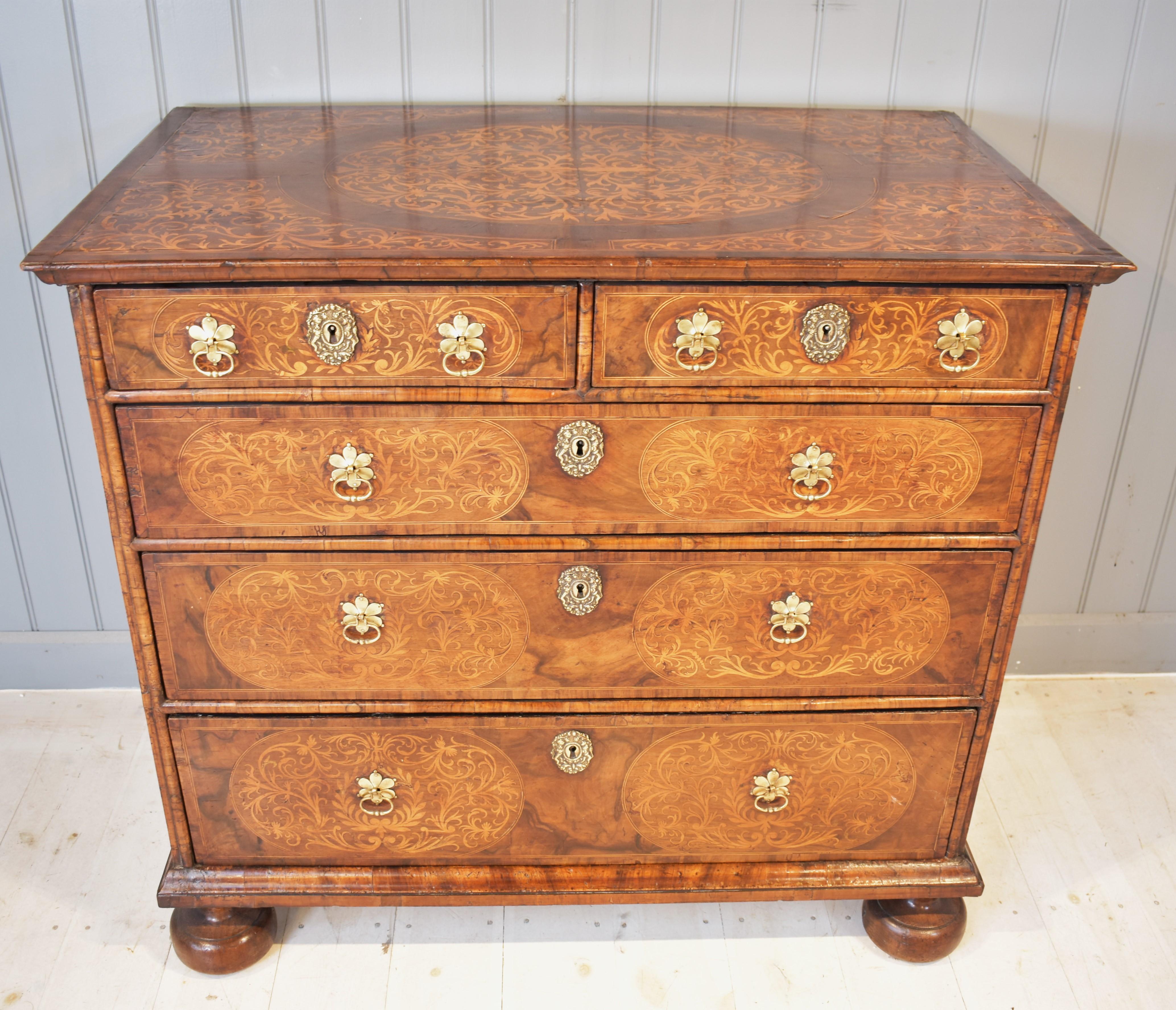 A walnut and seaweed marquetry William and Mary chest of drawers. The marquetry on the drawer fronts and top is of stunning quality with the use of ebony and boxwood stringing around the medallions of marquetry. The top and bottom mouldings of the