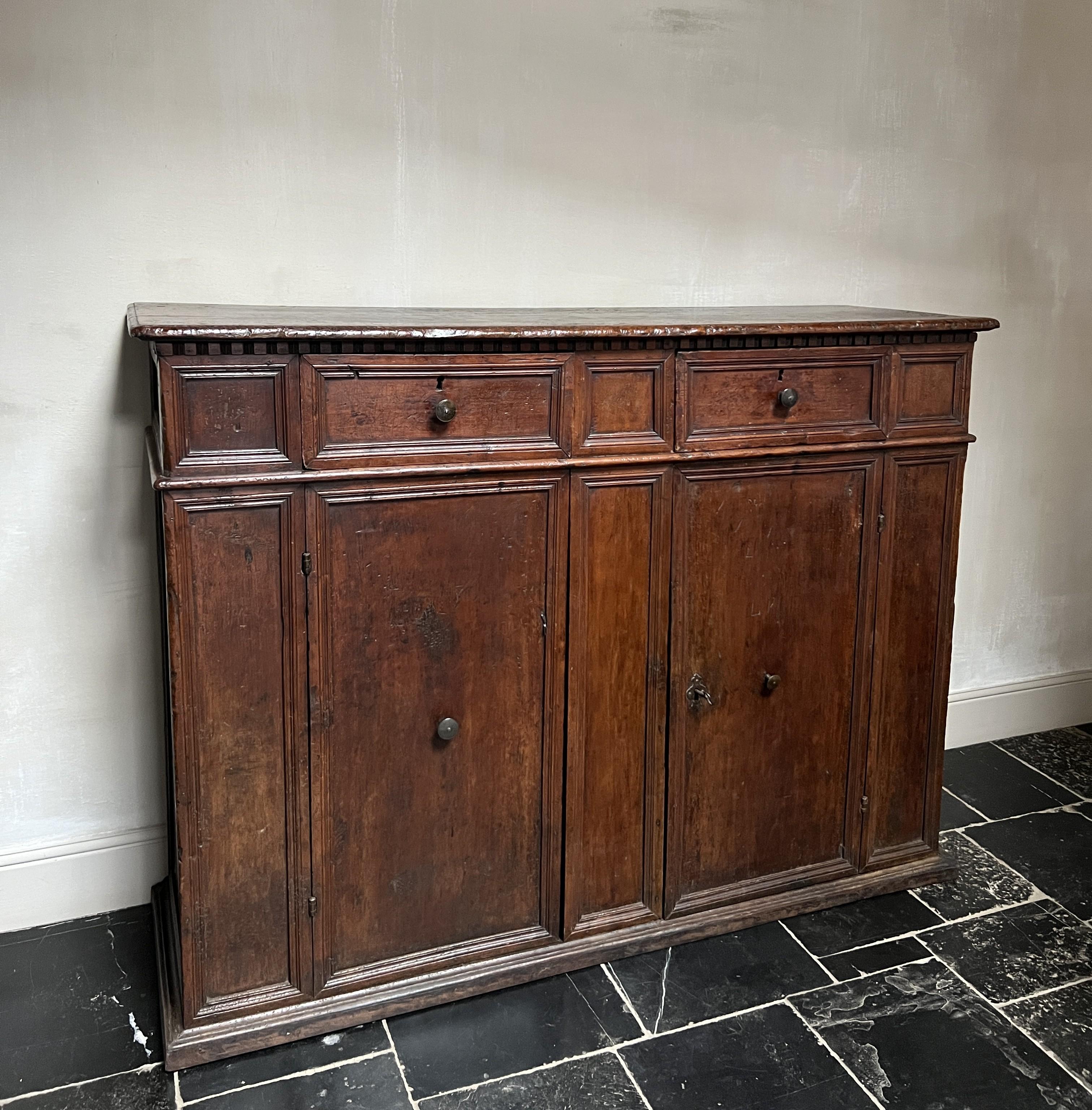 Un bellissimo e puro esempio di buffet italiano, probabilmente toscano. Realizzato in noce massiccio con tutti i pannelli ricavati da un'unica lastra. Tutto l'hardware originale è ancora presente. 
Ottime proporzioni e dimensioni pratiche.
Inoltre,
