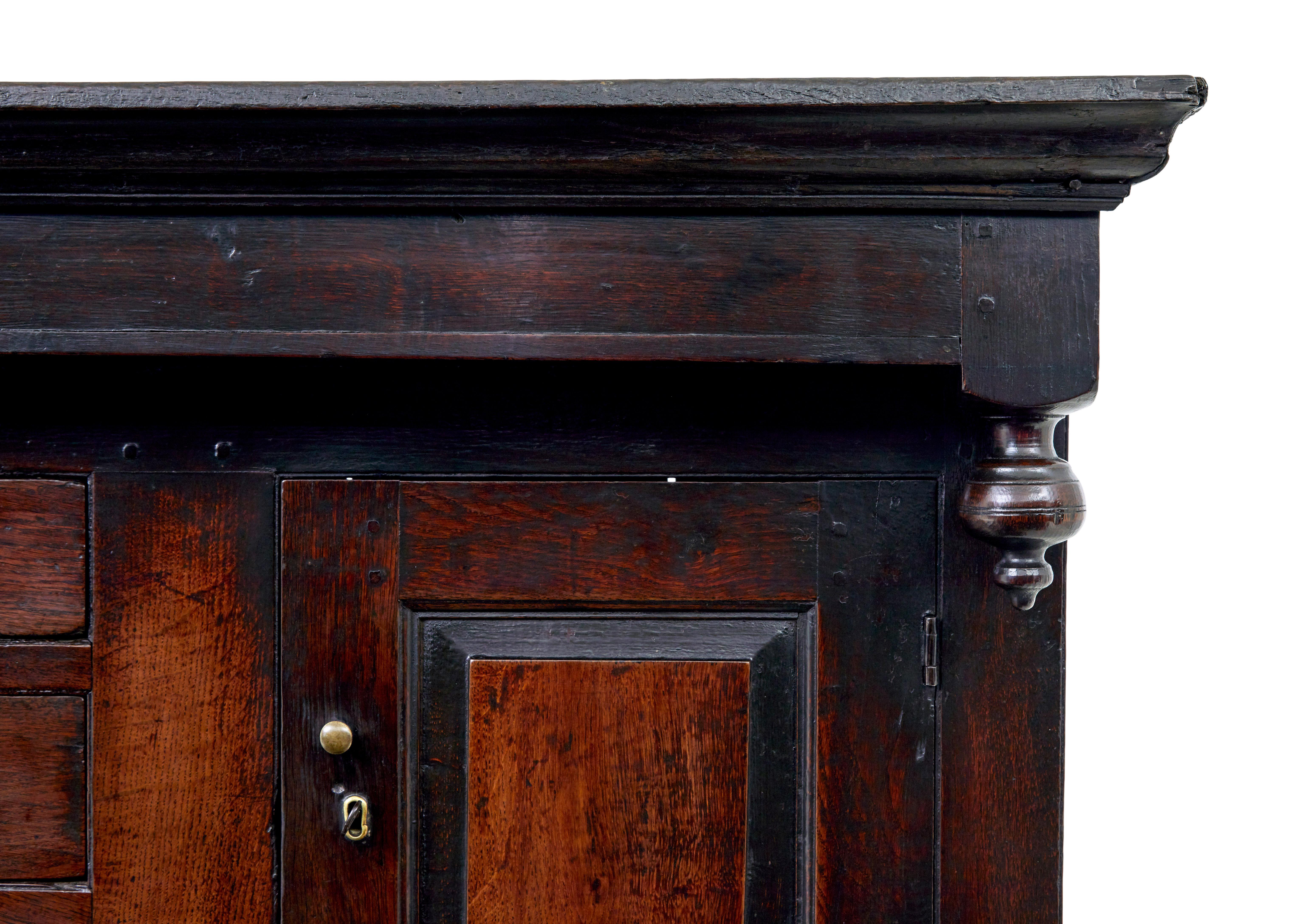 17th century welsh carved oak court cupboard circa 1680.

Comprising of 2 parts.

Top section with a central bank of drawers flanked either side by a single door cupboard.

Bottom section with 3 drawers below which a double door cupboard containing