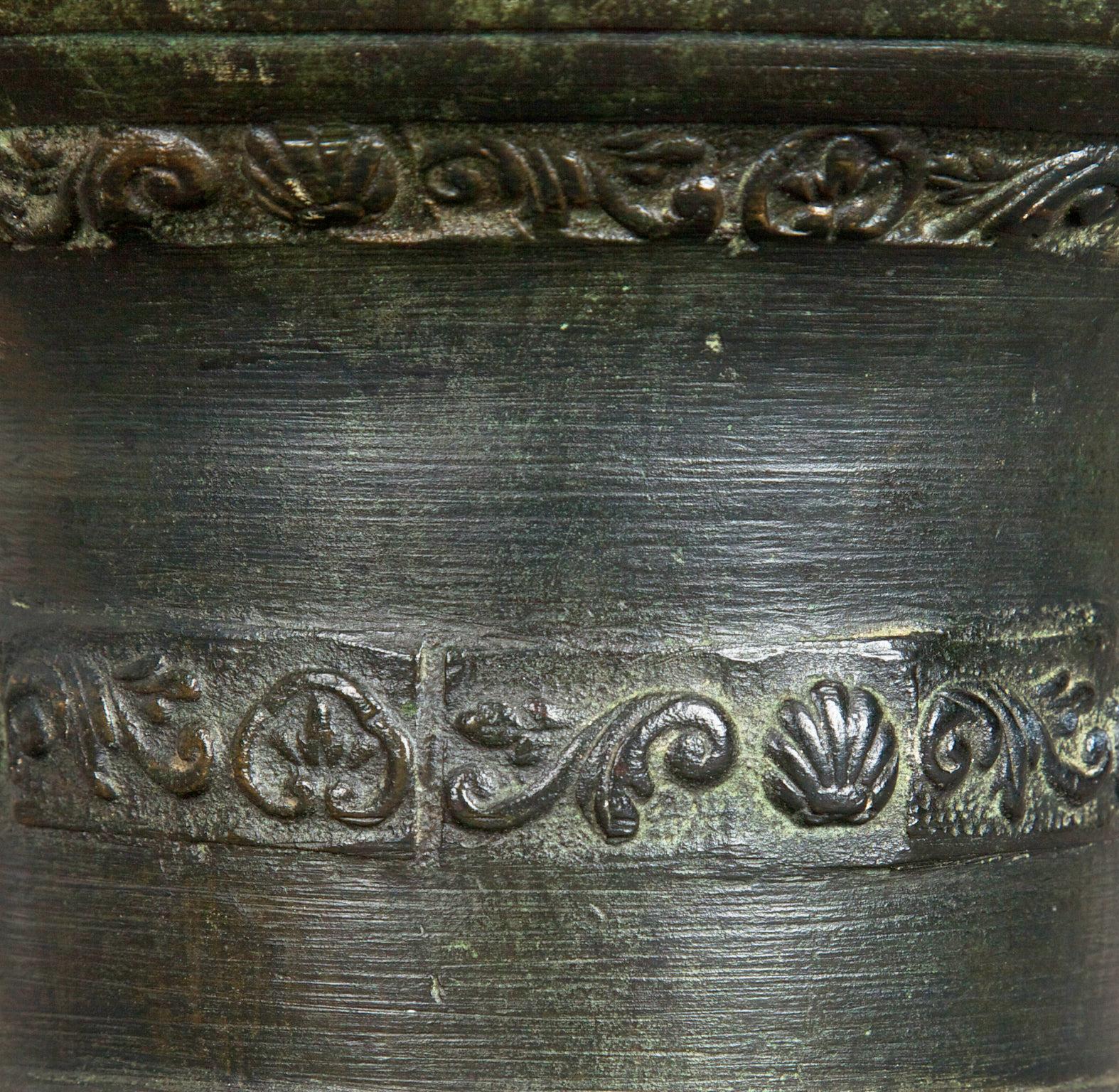 Mid-17th century lead bronze mortar. English, Whitechapel, London, circa 1630-1650

The deep rimmed mortar cast with a scrolling floral pattern under the lip, the body with further band of interlace centered upon scallop shells. From a presently
