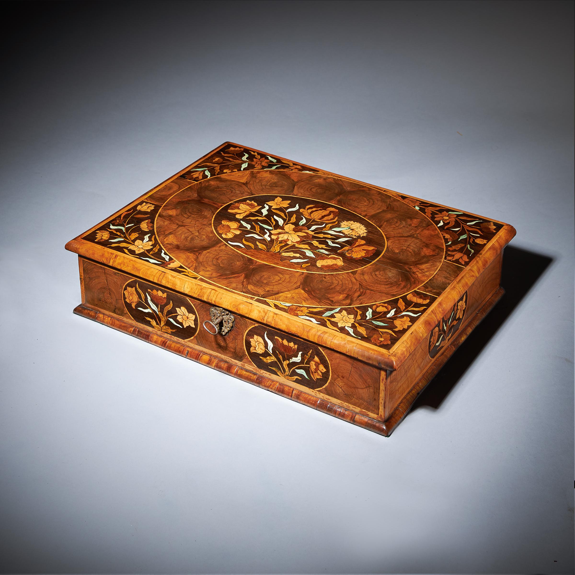 A fine and rare 17th century William and Mary olive oyster marquetry lace box, circa 1670-1690. England

The ovolo-moulded and holly banded top is centred by an oval of marquetry depicting spring flowers bordered in oysters of olive finely strung