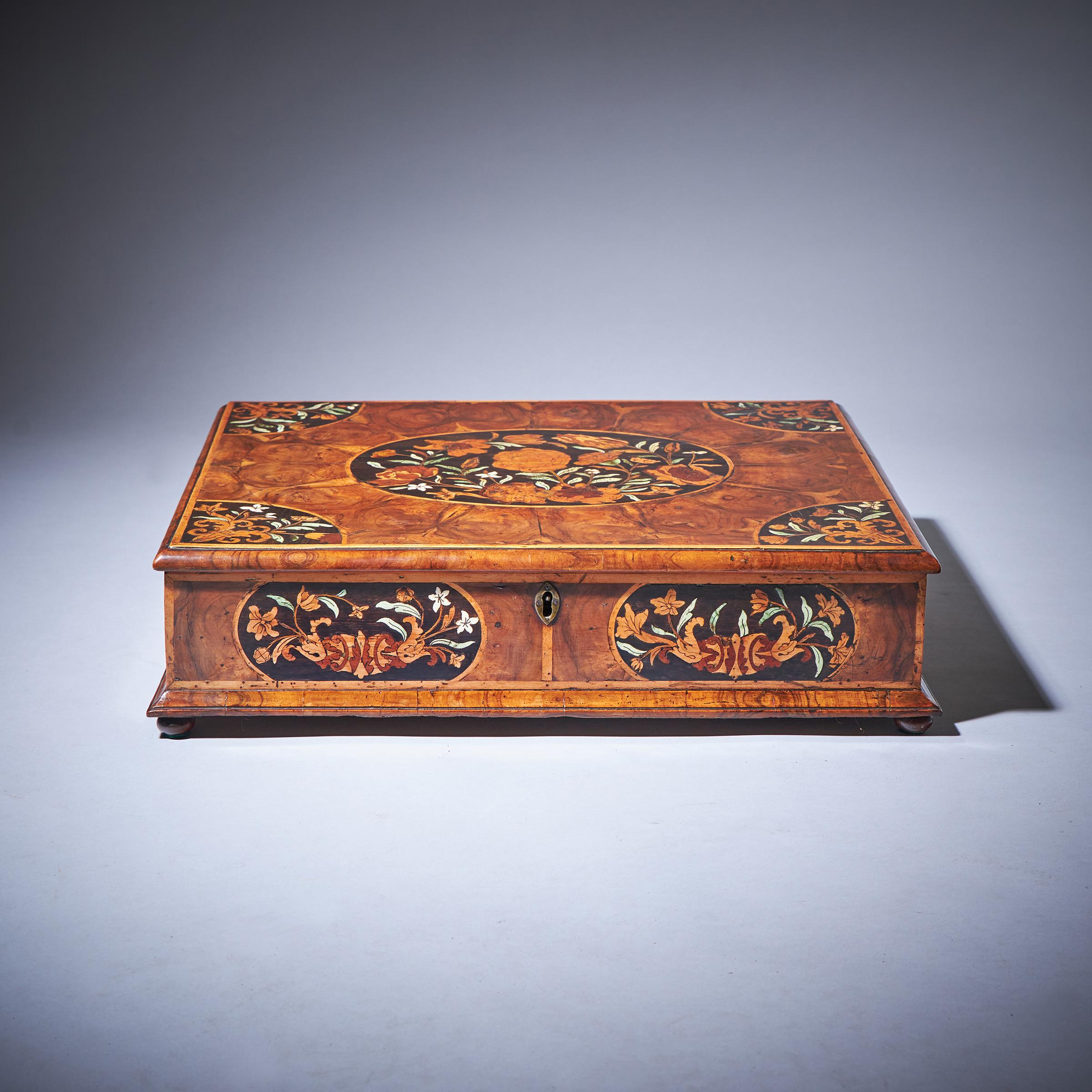 A fine and rare 17th-century William and Mary olive oyster floral marquetry lace box, circa 1685. England

The cross grain olive moulded and holly banded top is centred by an oval of marquetry depicting spring flowers and green stained bone leaves