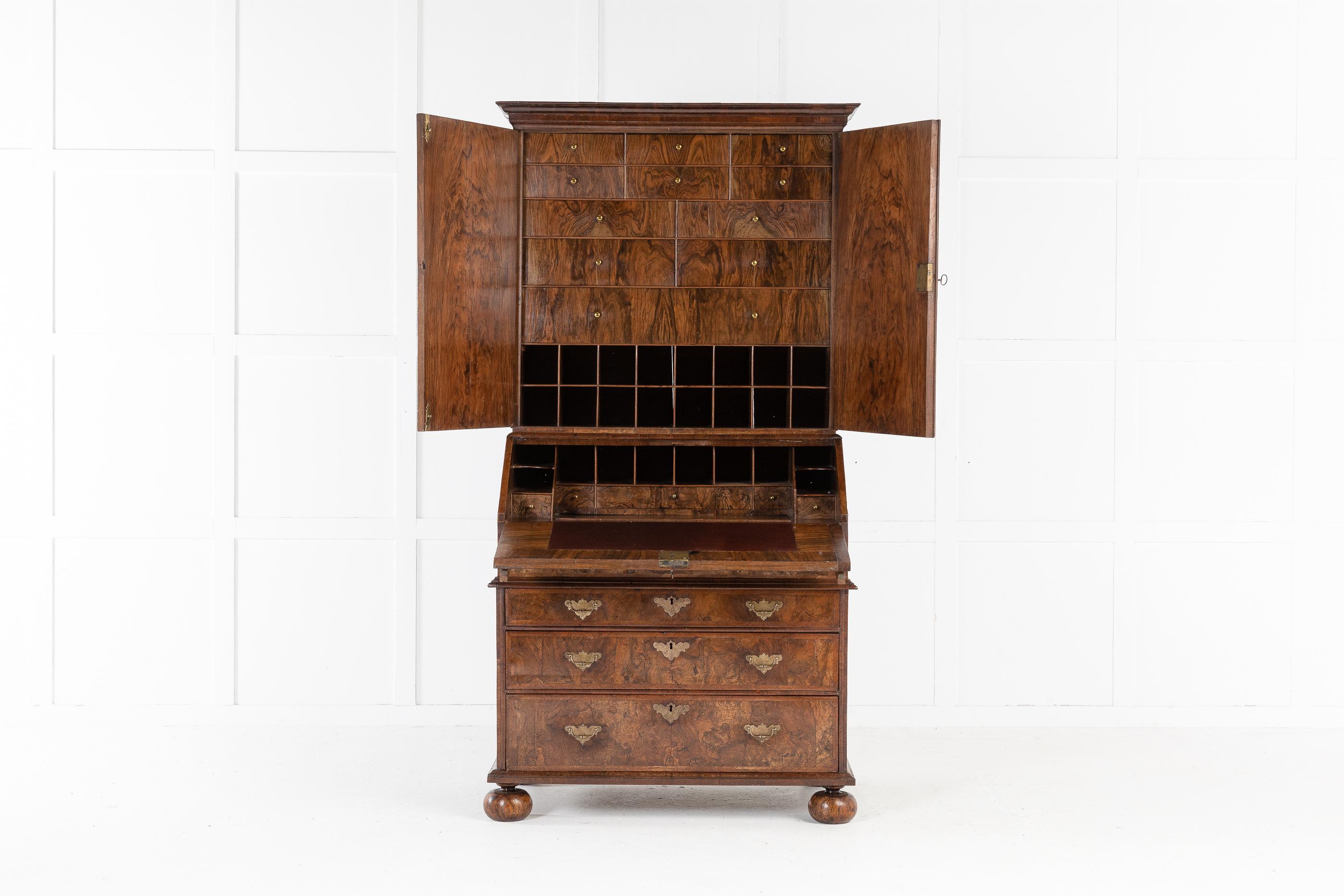 Rare, small proportioned, 17th century William and Mary period, highly figured, walnut bureau cabinet, retaining a wonderful color and patination. The top section has quarter veneered doors using quality veneer. The feather and cross banded doors