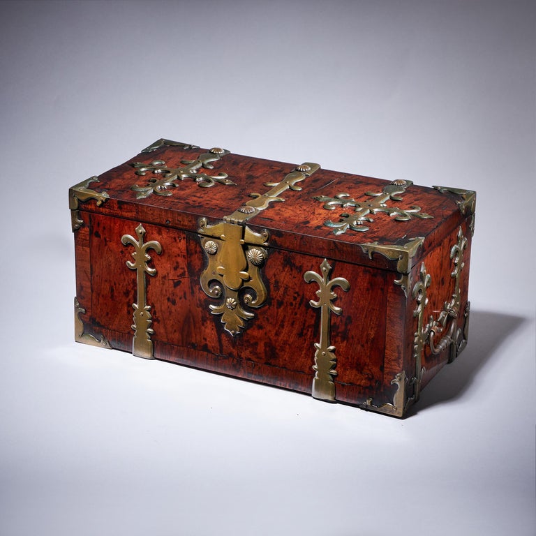17th century William and Mary Period walnut strongbox or coffre fort. 

A fine and rare walnut strongbox or coffre fort of unusual small proportions, adorned with highly decorative gilt brass strap work. C.1680-1700

The large gilt brass shaped
