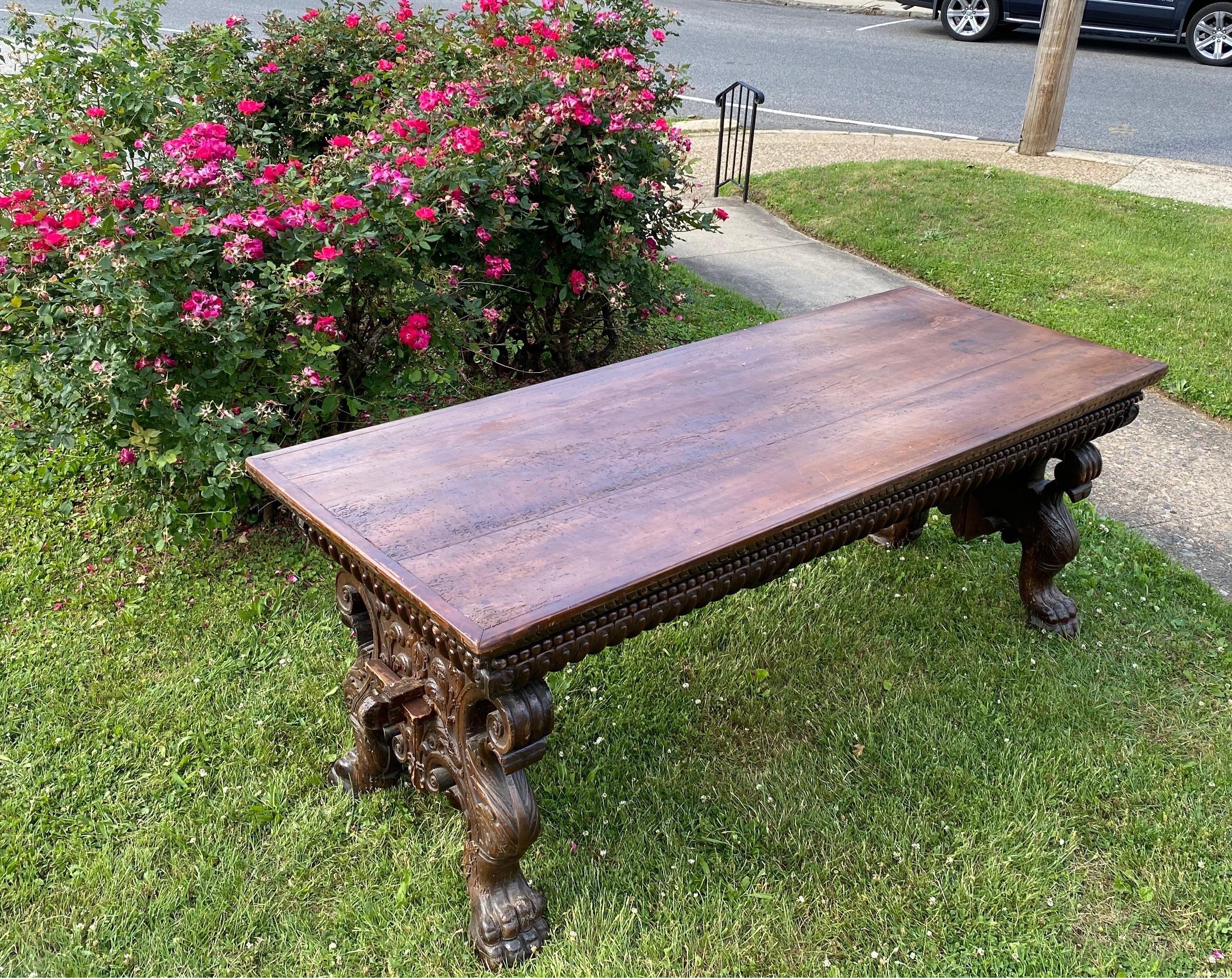 Incredible 17th-early 18th century Italian Baroque walnut trestle table from Tuscany. Hand carved throughout, this table features massive paw feet, scrolled knees and carved apron. Each base is made of 2 parts that come together to reveal a coat of