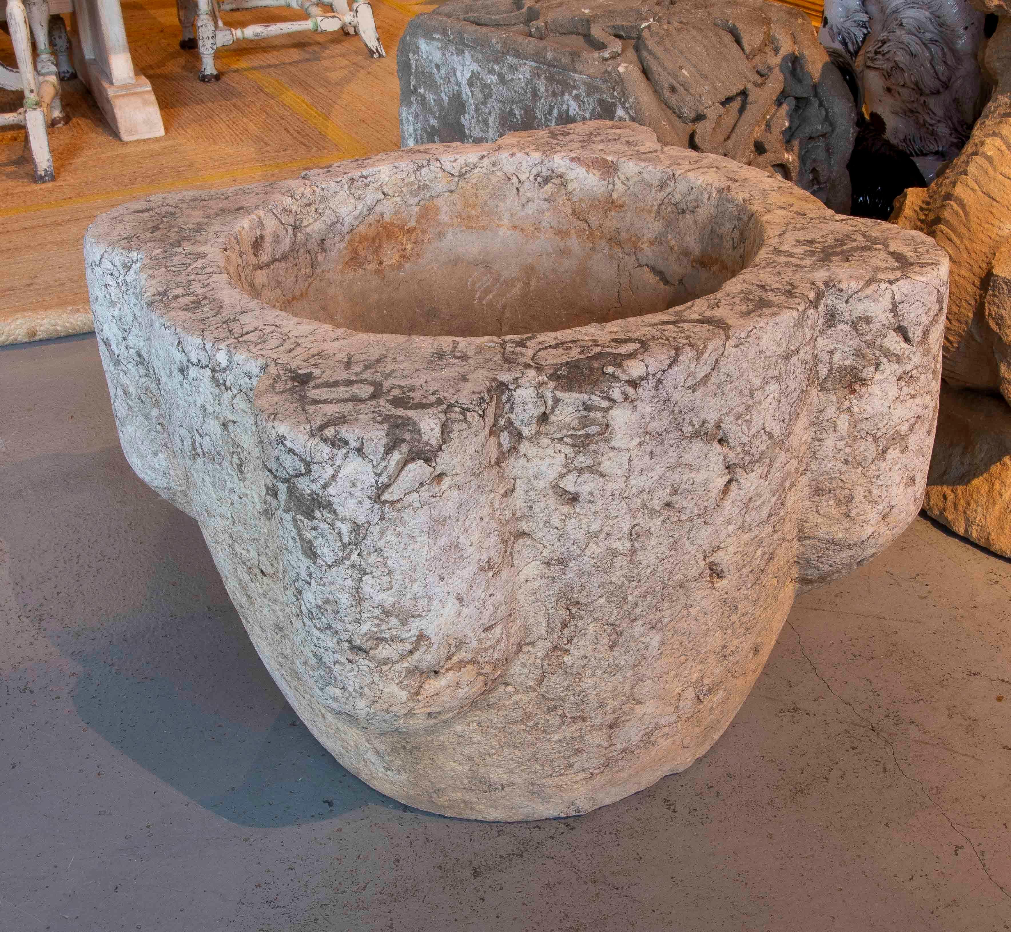 Impressive large antique mortar, hand-carved from a single block of solid stone. Its robust shape and deep cavity reflect its original use for grinding grains, herbs, and spices in domestic or communal settings.

A unique detail is the inscription