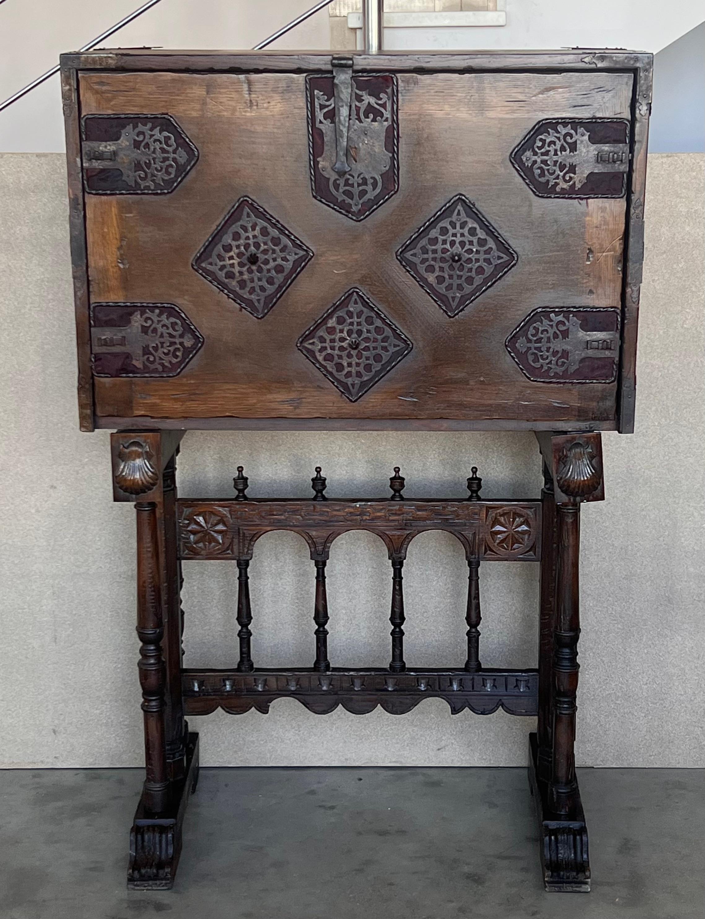 Spanish desk (“bargueño”) in walnut.
 17th century with “bridge-shapped”. Decorated on the exterior with metal applications (open-work, textile background) and bow handles with central lentil. It stands on a  