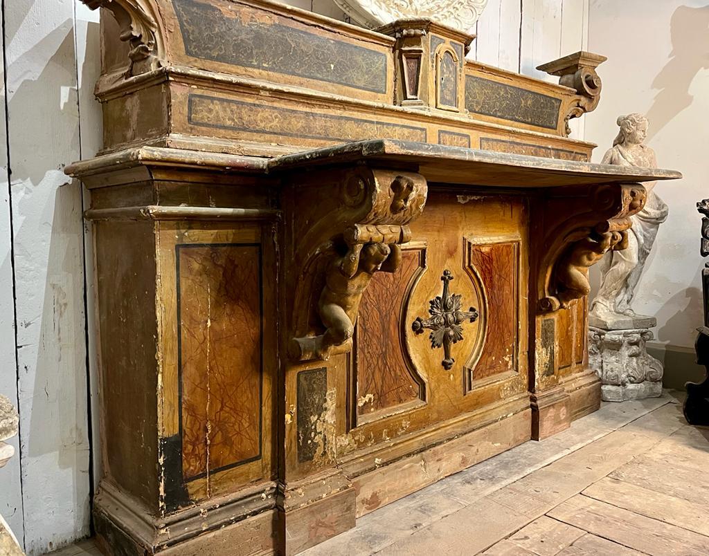 Wooden altar of late 17thC richly decorated.
Polychrome faux marble lacquer, embellished with carvings depicting putti with typical aesthetic characteristics of 17th-century Baroque.
The large size, the beauty of the decorations as well as the