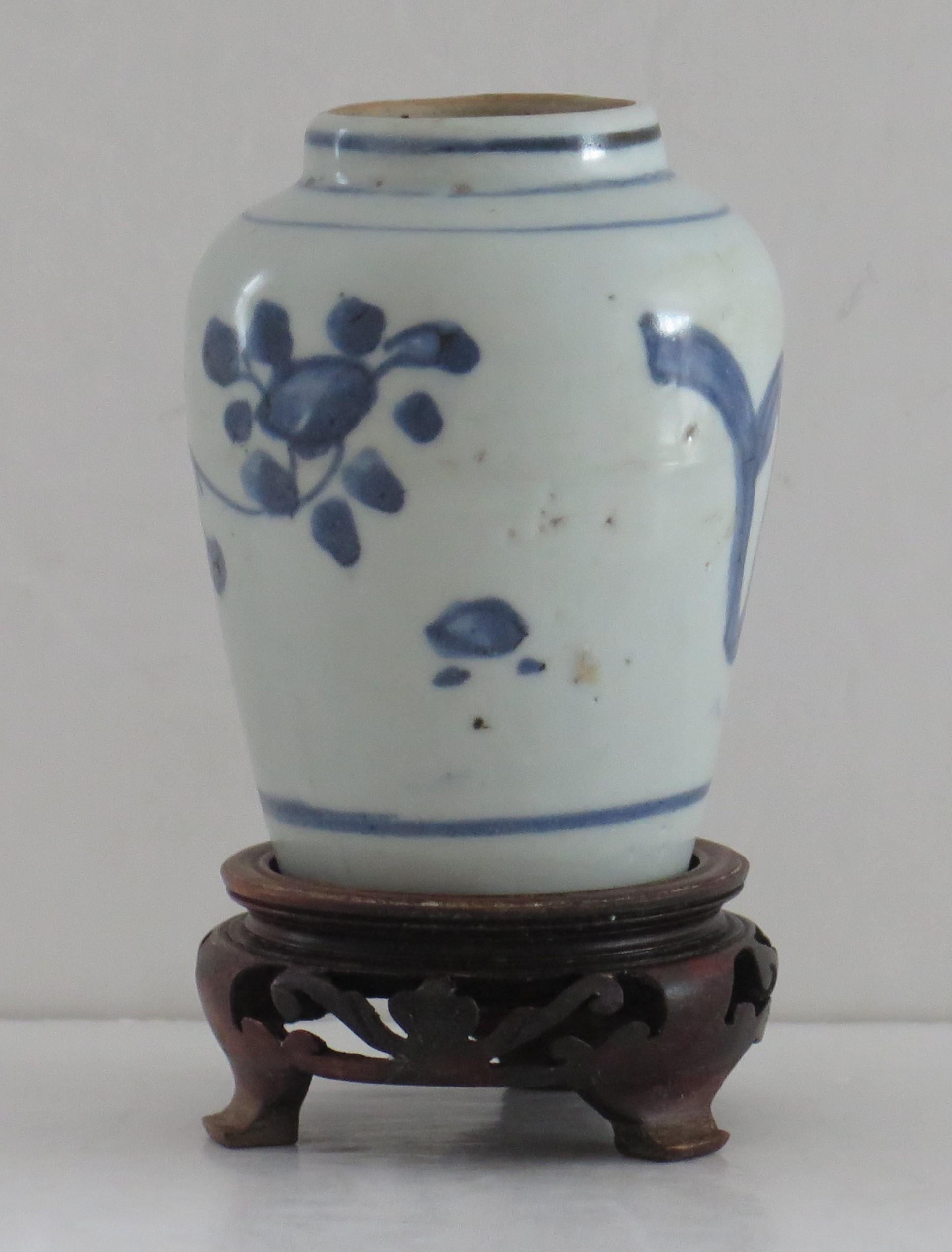 This is a hand painted 17th century, Ming dynasty, porcelain Jar or small Vase complete with a hand carved hardwood stand. 

The Jar is fairly thickly potted with no foot rim as is mostly the case with the early wares.

The Jar is decorated, in