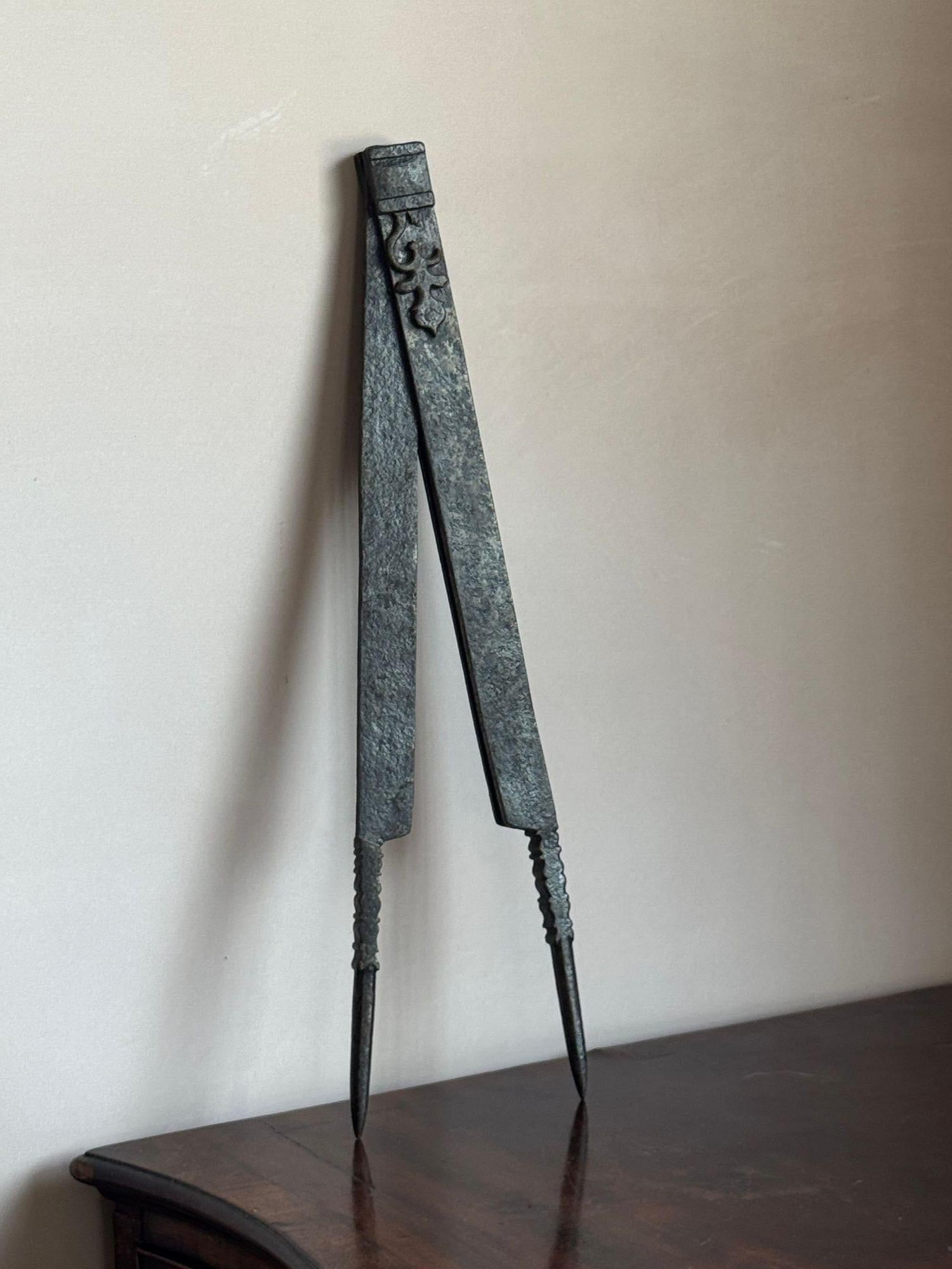 Une grande paire de diviseurs en acier précoce, probablement un armurier français, avec décorations à volutes à la section articulée supérieure. Probablement 17ème siècle. Une petite partie de la décoration est manquante sur un côté. Ils sont saisis