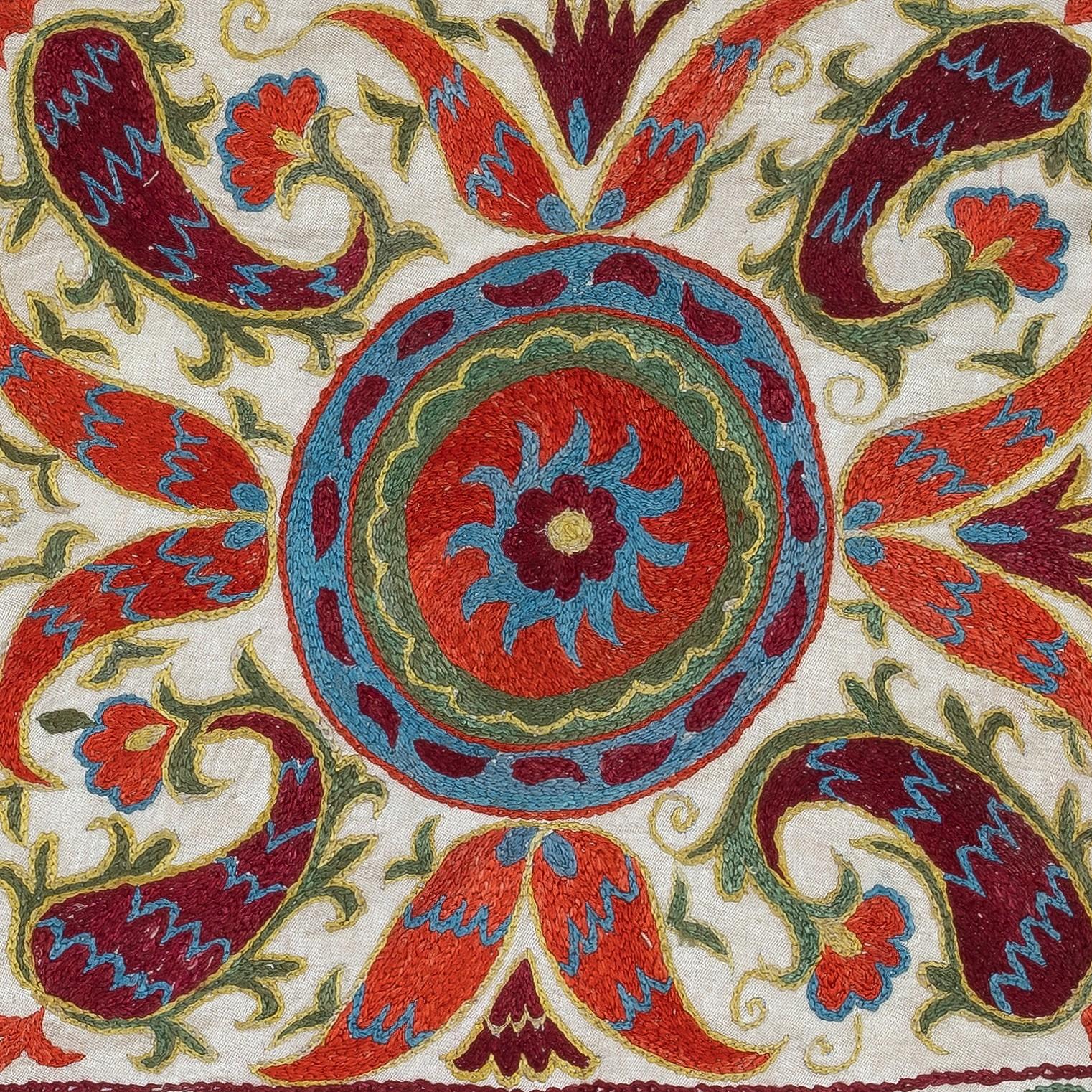 Insufflez à votre intérieur le riche héritage de l'Asie centrale avec cette exquise housse de coussin Suzani brodée à la main, fabriquée par des artisans qualifiés en Ouzbékistan. Ce magnifique textile est une véritable œuvre d'art. Il est orné