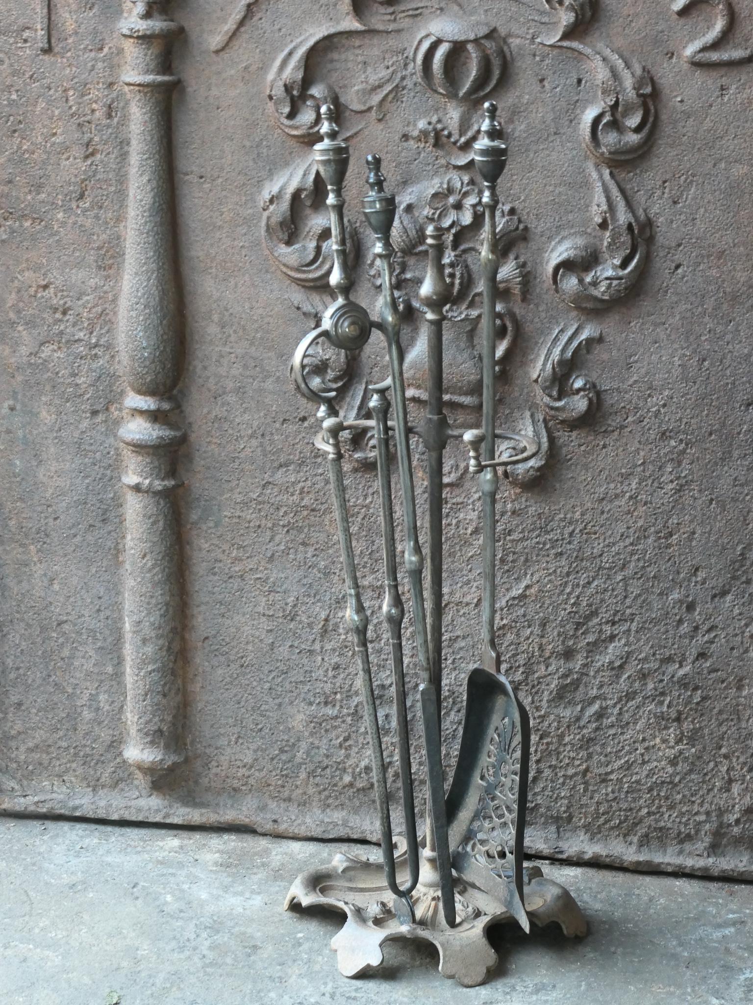 18/19th Century English Georgian fireside companion set. The tool set consists of thongs, shovel, poker and stand. Made of cast iron (stand) and wrought iron (tools). It is in a good condition and is fully functional.