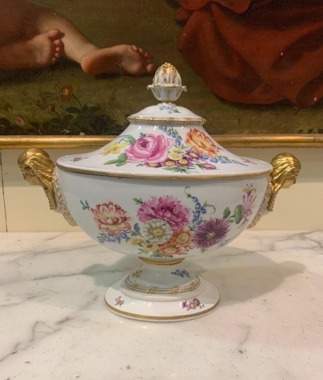 Important porcelain soup tureen with polychrome decoration of flowers and gilt highlights, the handle of the seed lid, the handles with Egyptian busts and laurel festoons. Maissen Dimensions: 36.5 x 42.5 x 23 cm.