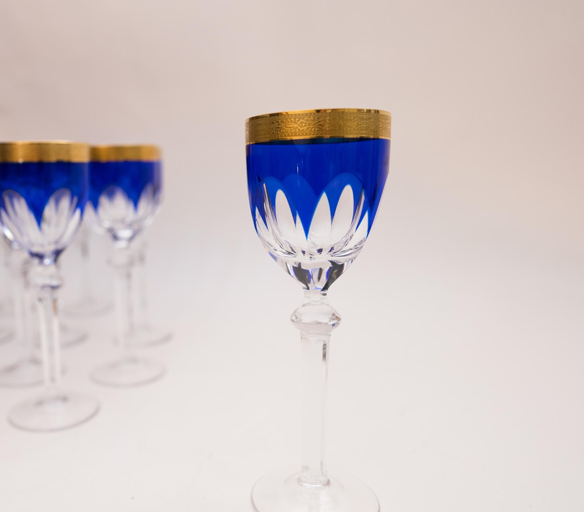 Scarce and hard to find matching set of 18 antique cobalt blue and gold cased crystal goblets. This set has a nice crisp cased and cut to clear cobalt blue bowl with a cut knob stem as well. The 24 karat gold band measures an half inch and it is