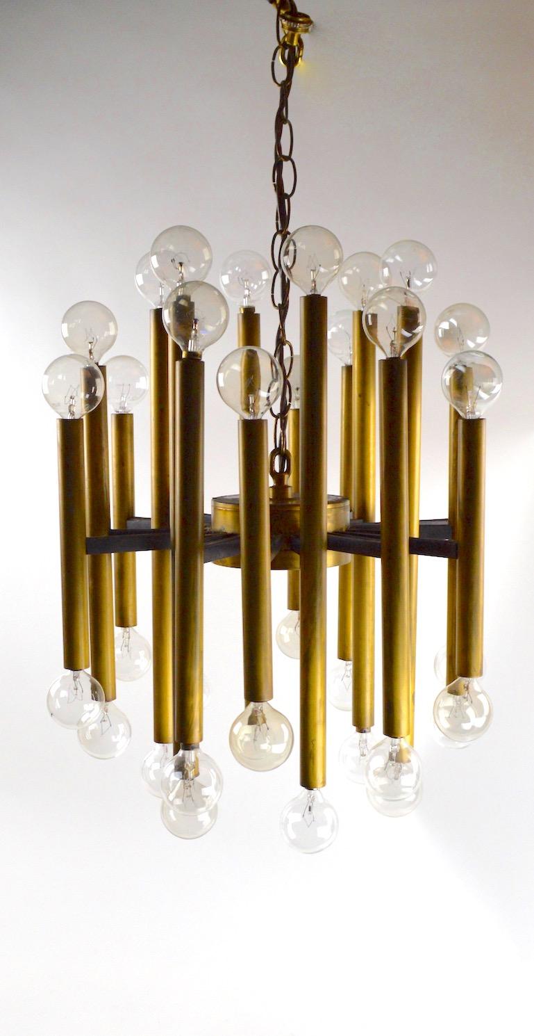 Very fine Baton style brass and cast iron spoke form chandelier. Composed of vertical brass elements, each having standard screw in sockets at top and bottom. The chandelier can be used with both top and bottom bulbs in place, or just the top or