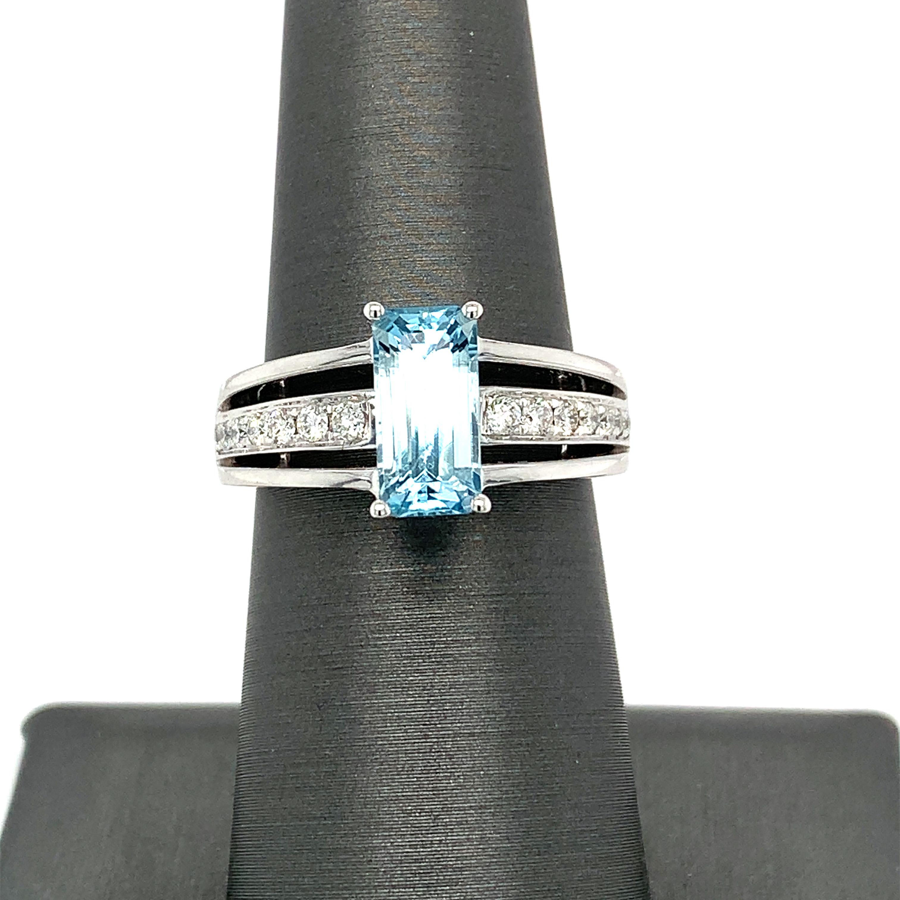 El anillo de aguamarina talla esmeralda de 1,8 quilates tiene detalles de diamantes en la banda para elevar su aspecto sencillo. La aguamarina central está engastada con cuatro garras y tiene una hermosa galería inferior. Hecho a mano por un