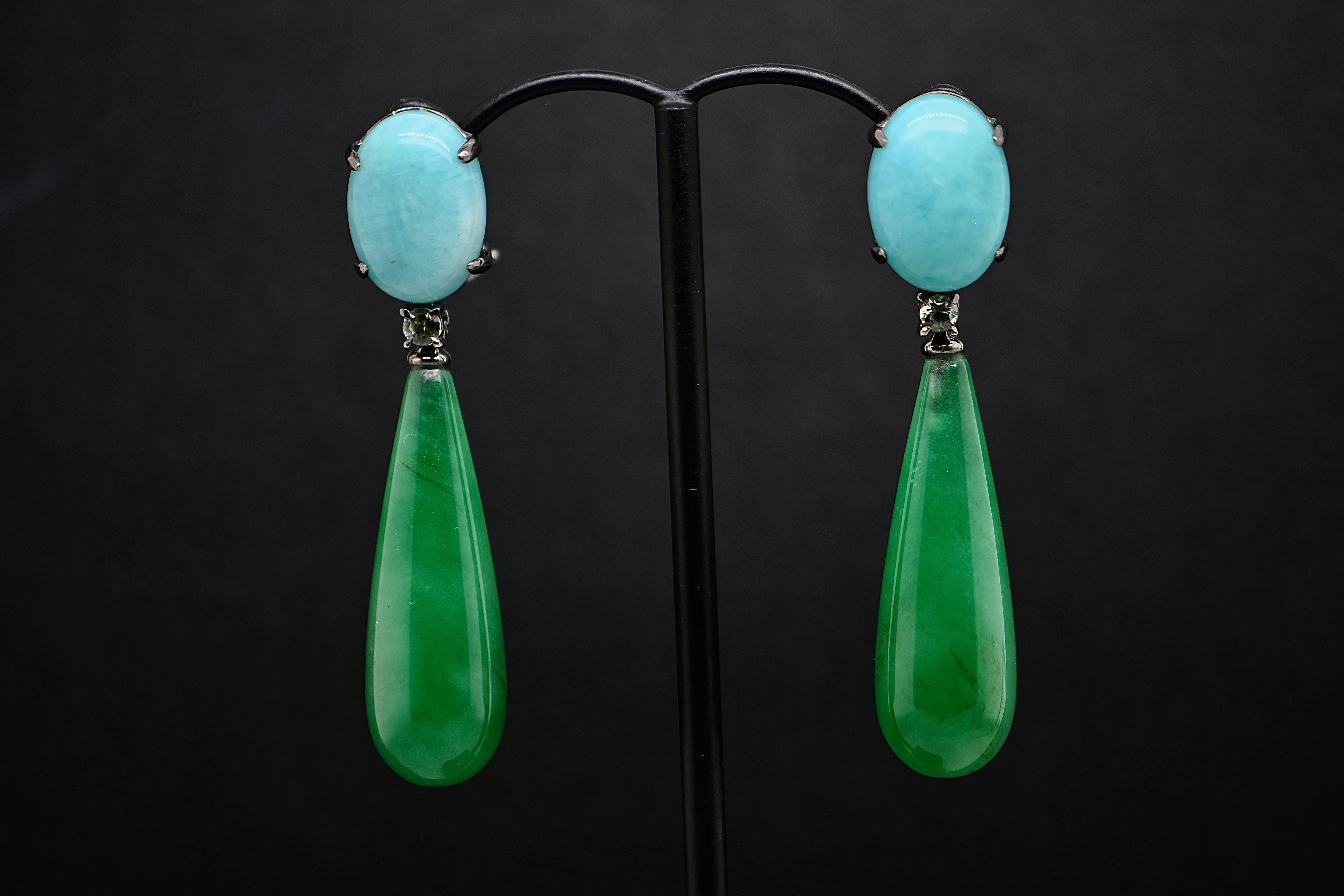 Exuding timeless elegance, these 18-carat black gold earrings feature exquisite amazonite and jade stones adorned with dazzling sapphires. With a length of 5 cm, they gracefully cascade from the ears, commanding attention with their captivating